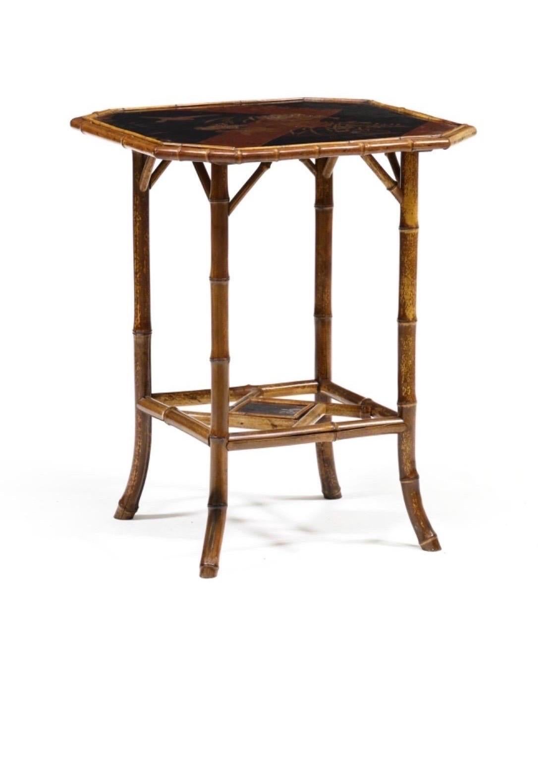 Magnifique table d'appoint en bambou de style Chinoiserie. Bambou de la fin du 19ème siècle. Le cadre comporte des panneaux laqués décorés de motifs aviaires et floraux traditionnels. Tablette inférieure laquée et pieds évasés.

Magnifique mélange