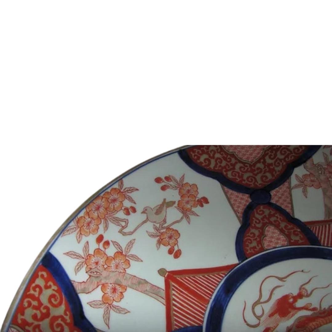 Japanese Imari porcelain plate charger.
Late 19th century.
Decorated in the traditional manner in red, blue and gilded glazes upon a white ground.
Central medallion with fierce, undulating dragon.
The surrounding alternating panels featuring a