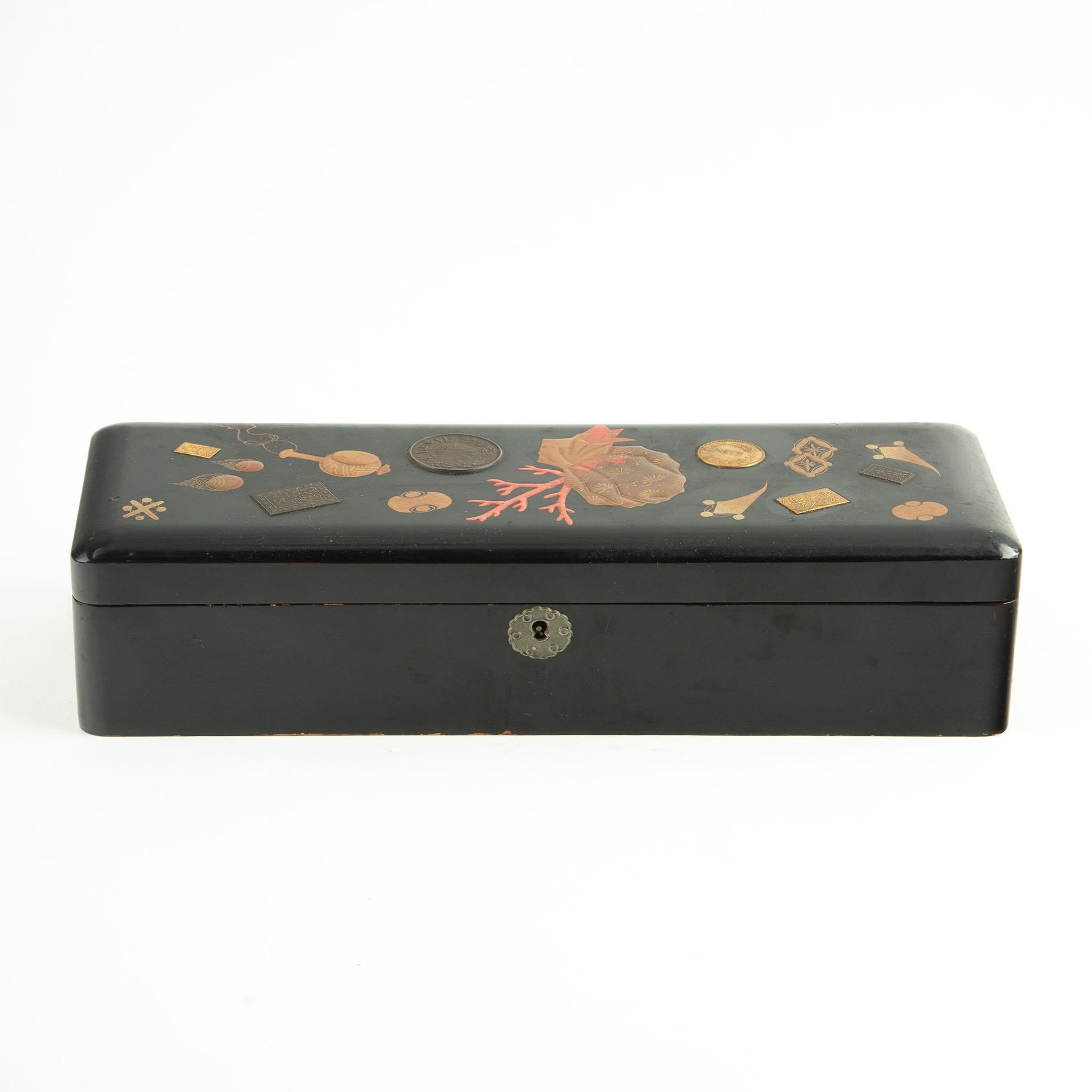 Late Meiji to early Taishō period Japanese lacquer box (circa 1890–1920), decorated in the takaramono (宝物, “treasures”) motif, symbolizing prosperity, longevity, and good fortune. The design incorporates finely detailed representations of auspicious