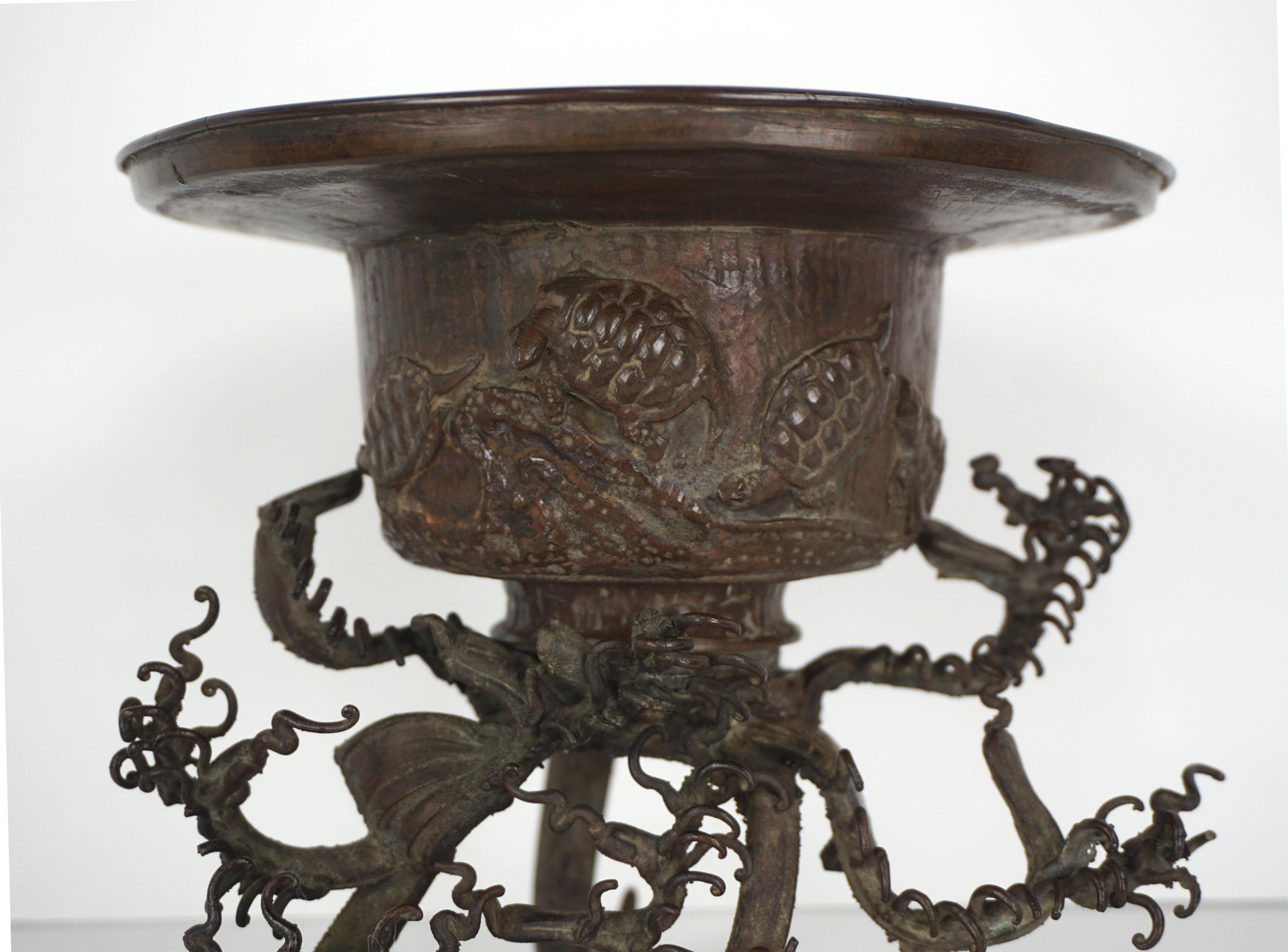 Beautiful two-piece Japanese bronze usubata, a vessel for ikebana flower arranging, with intricate wave form base, Meiji period, late 19th century, Japan. The usubata vessel has four charming turtles and sets on a separately cast base designed as