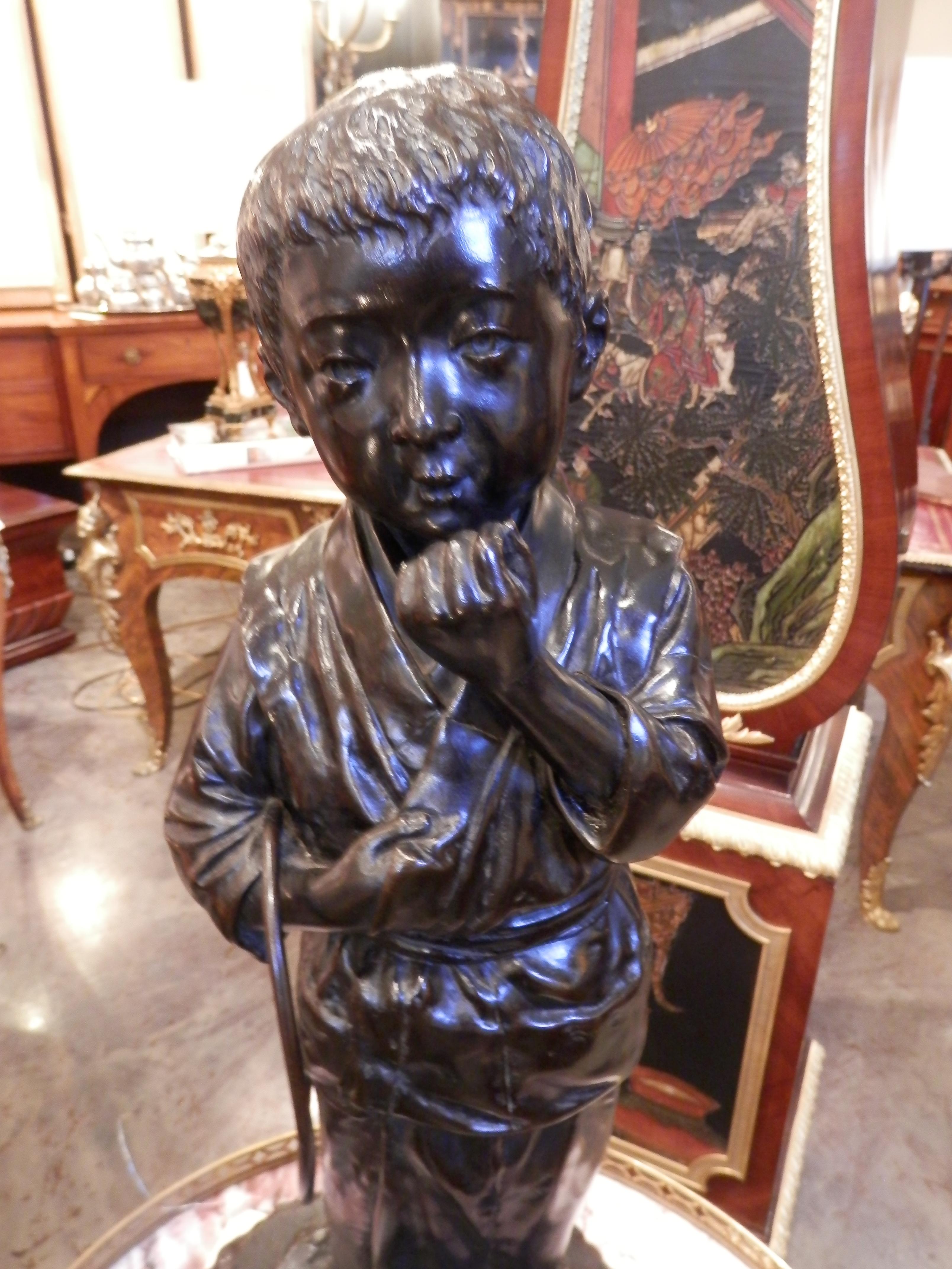 Beautiful large late 19th century Japanese bronze of a boy in a kimono and sandals. Carved naturalistic wood base.