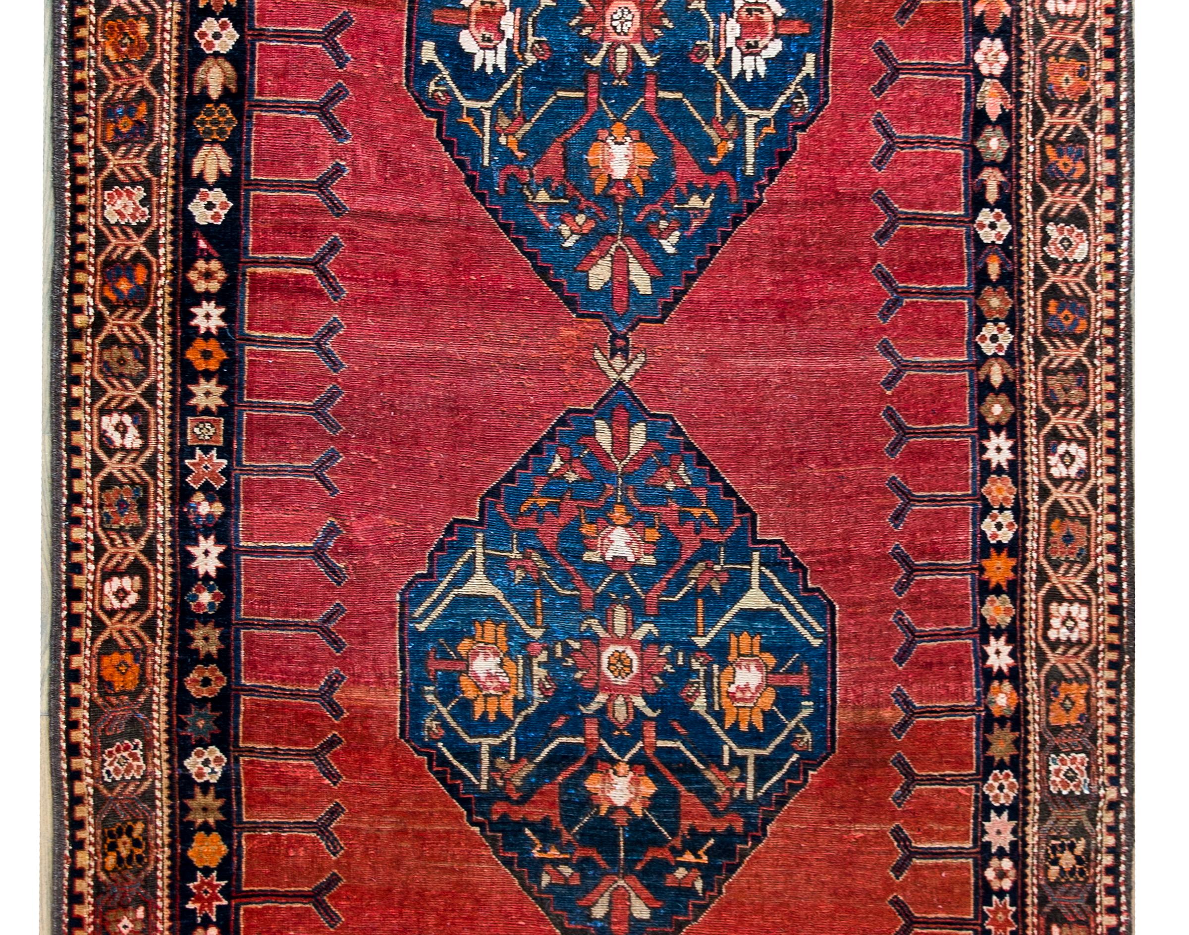 One of the most beautiful rugs we've seen in a long time!  A stunning late 19th century Karabakh rug with three large indigo medallions each with stylized flowers and scrolling vines on a gorgeous abrash crimson and orange ground.  The border is