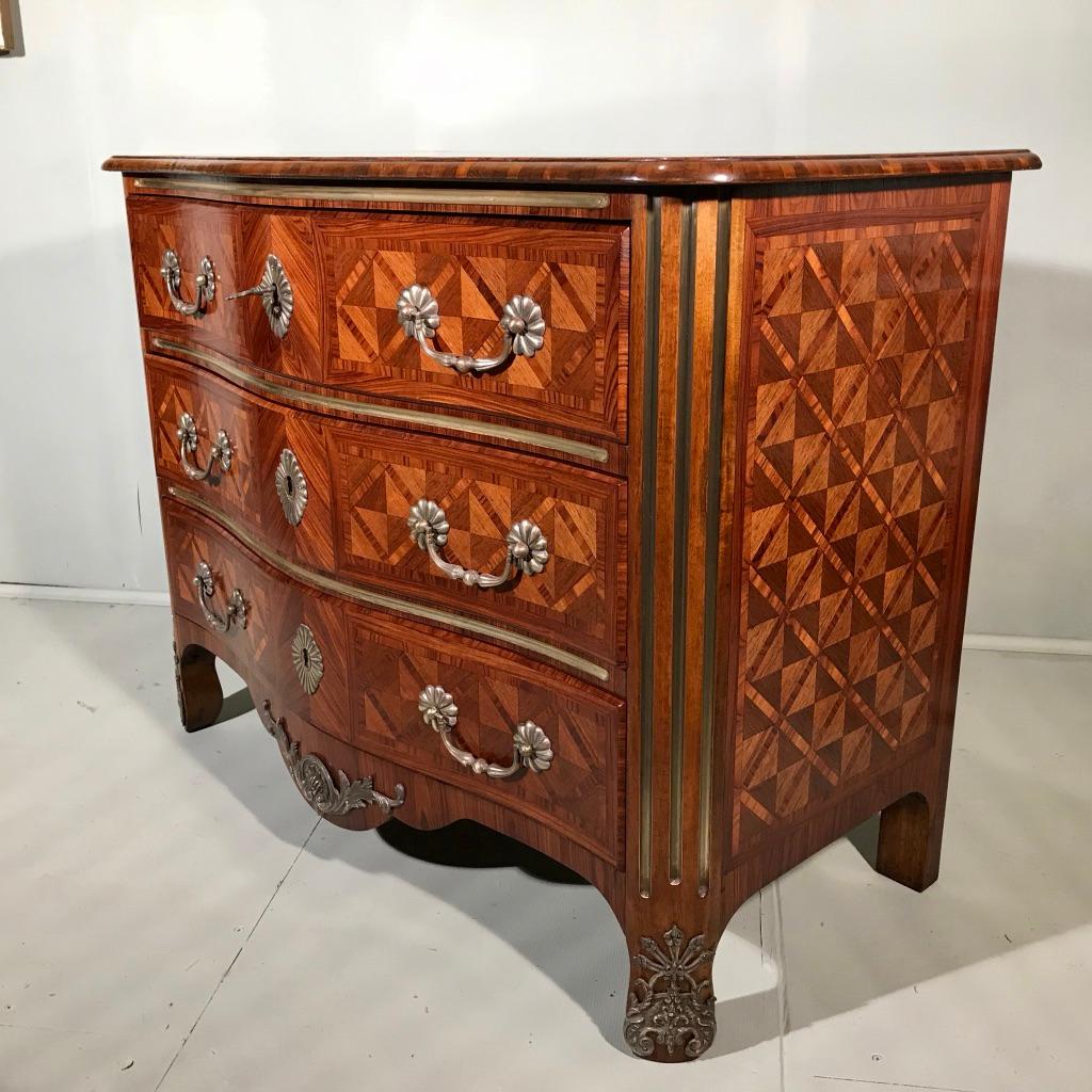 This is a really superb quality and condition French 19th century serpentine front commode chest of drawers in kingwood and walnut geometric parquetry and all original brass mounts and brass inlay.
The top is finished with an end grain moulded