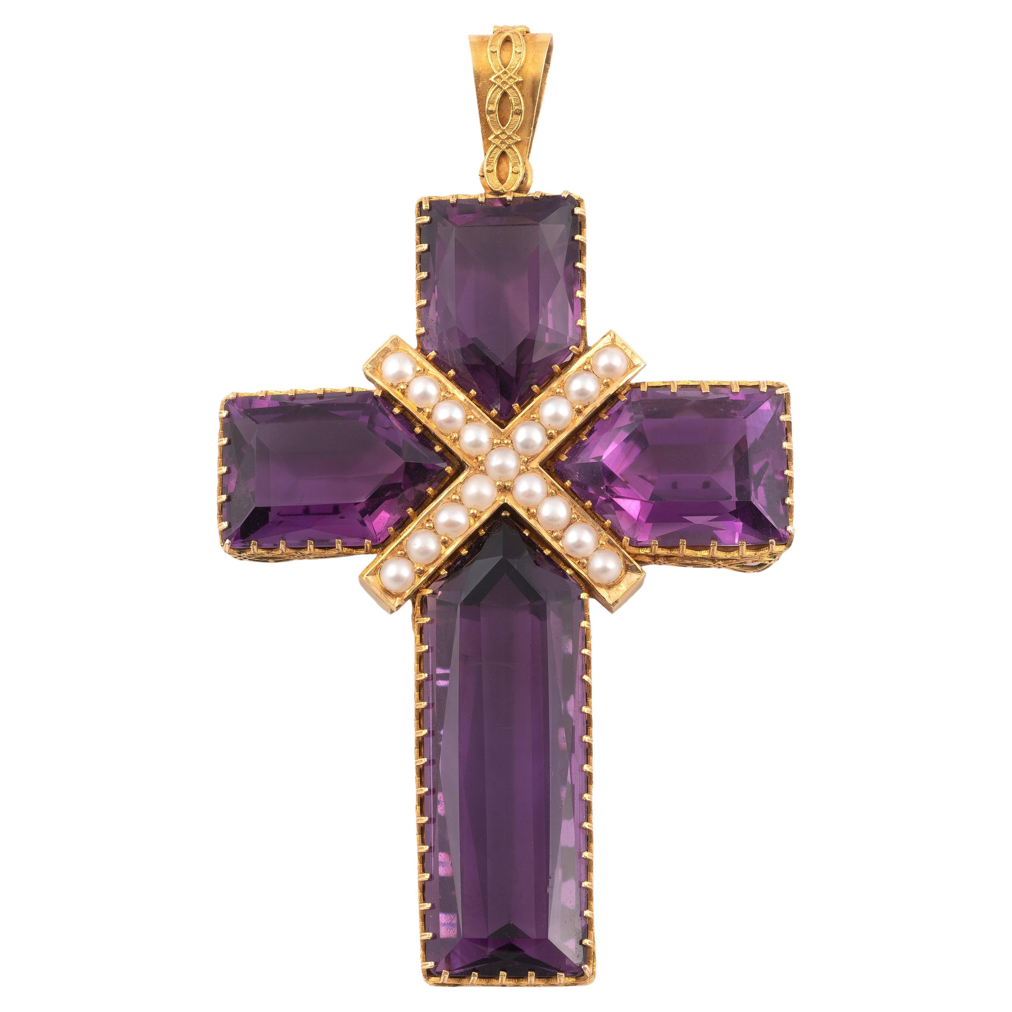 Importante colgante en forma de cruz compuesto por 4 amatistas escalonadas en engaste de garra, centrado con una cruz de San Andrés adornada con una línea de perlas. El engaste de oro amarillo está adornado con un friso de entrelazos, la fianza con