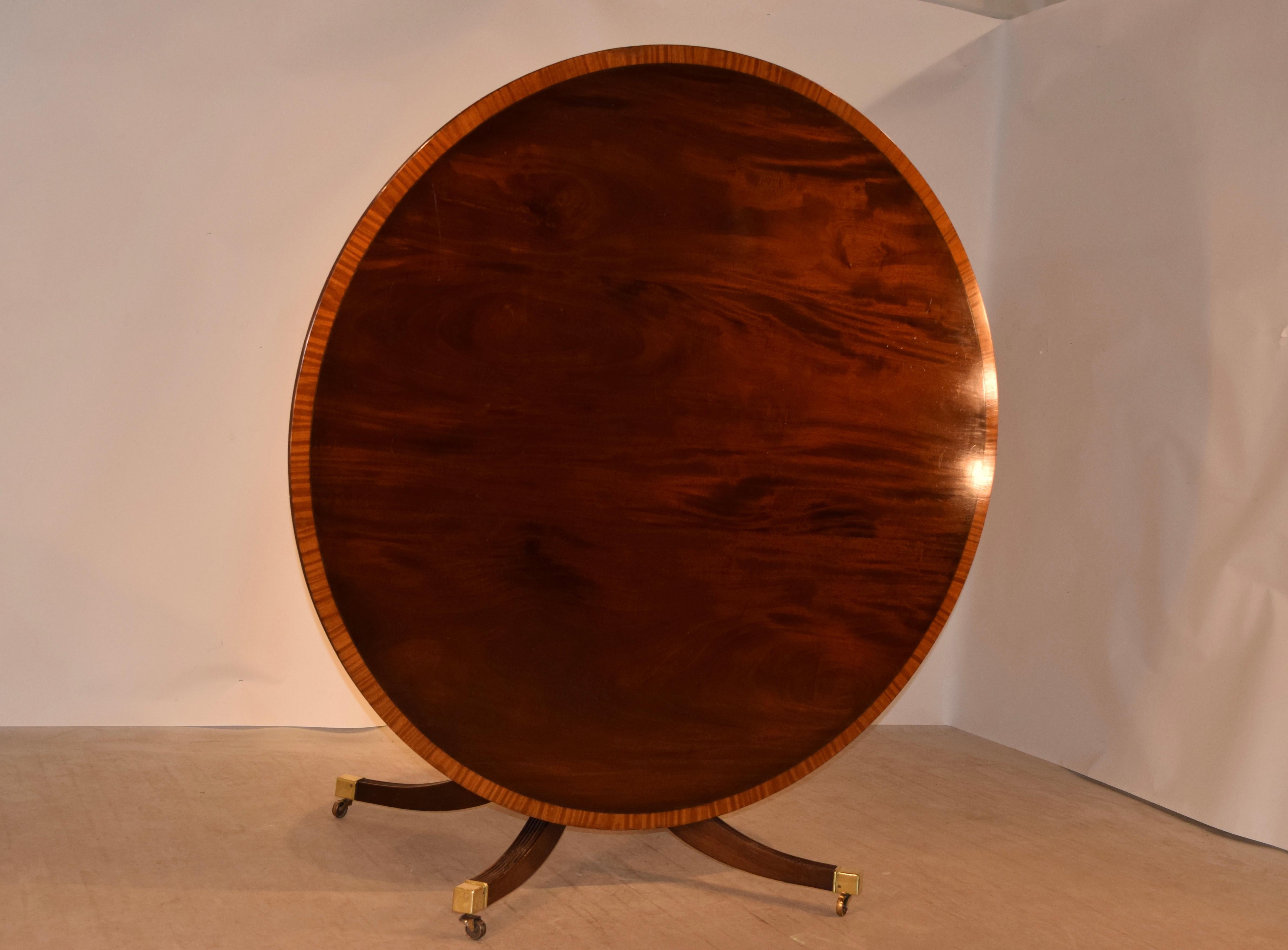 Late 19th century large mahogany tilt-top table from England. The top is banded in satinwood for a lovely contrast against the wonderfully grained mahogany top. This follows down to a hand-turned pedestal base with four legs. One of the feet has an