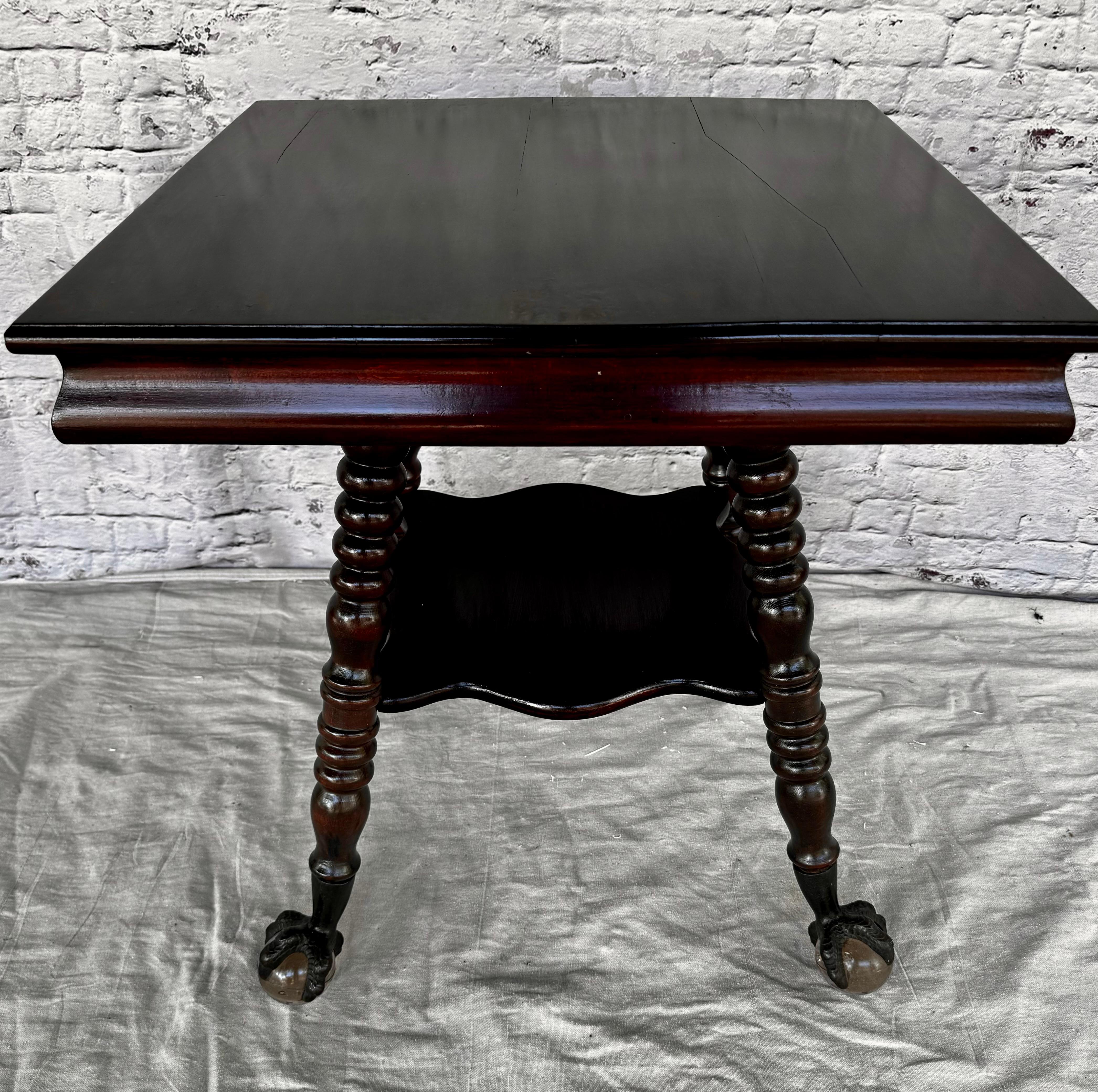 Table d'appoint unique en acajou de la fin du 19e siècle pour bibliothèque/parloir. La table est dotée d'un plateau carré plat et d'une étagère centrale plus petite.  La table est soutenue par de magnifiques pieds tournés en spirale qui se terminent