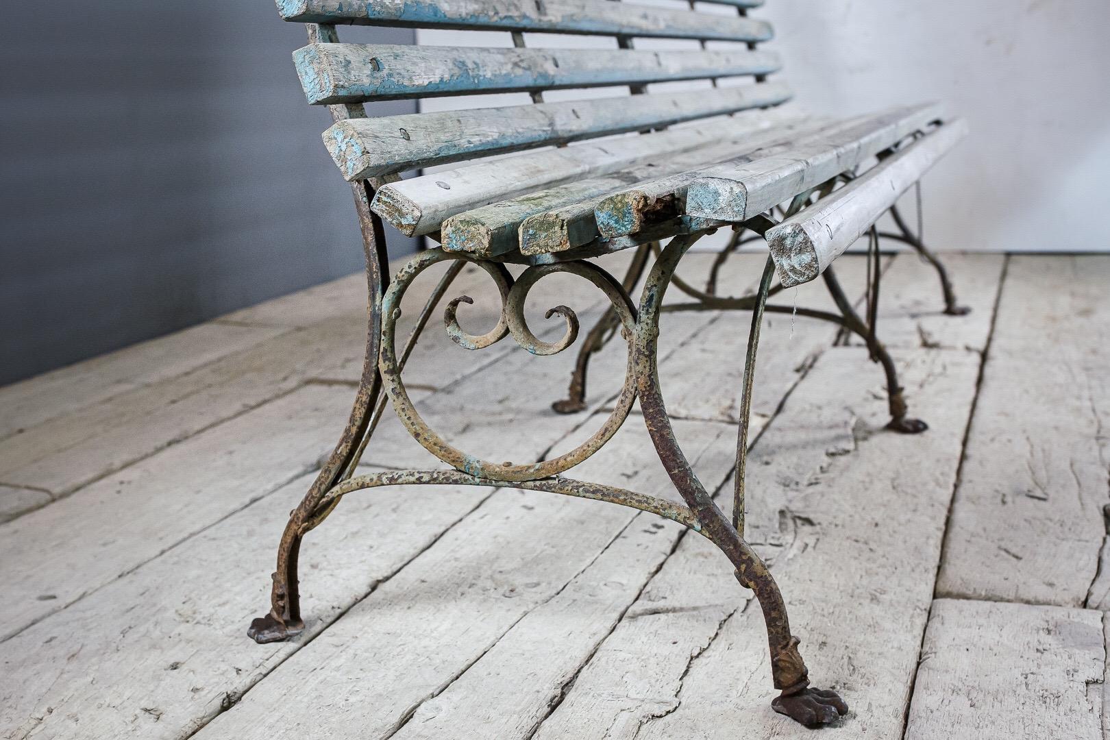 Late 19th century large Arras garden or conservatory bench, sculptural wrought and cast iron 6 legged base. Earlier lion paw feet model. Unusual wood slat model, solid and sturdy with historic paint. Wonderfully sculptural, dry original surface.