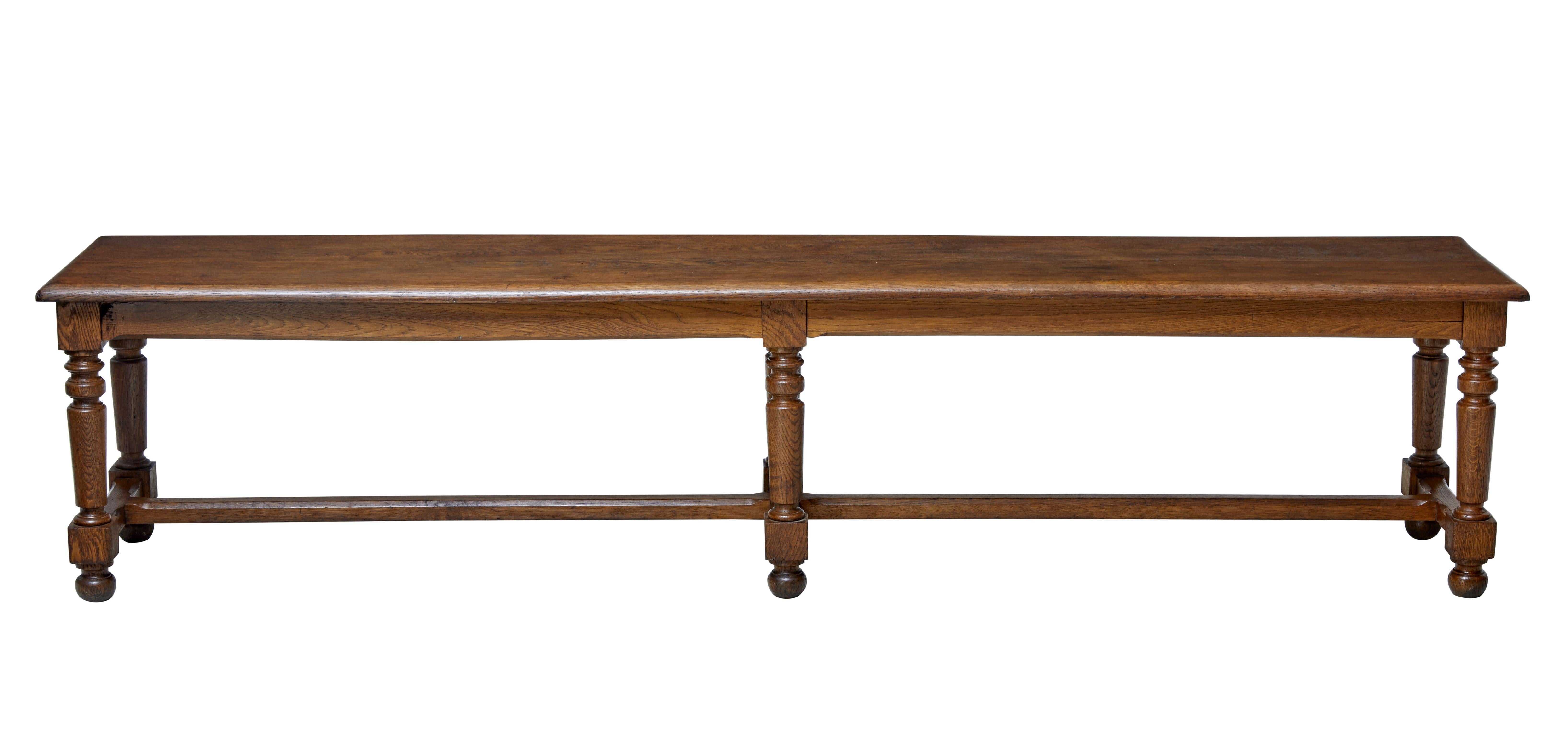 Large late 19th century bench made in oak, circa 1890.

Ideal for use in a hallway or cloak room. At near 2 meters long this bench can provide seating for a comfortable 4 - 5.

Standing on six turned legs united by stretcher. Single piece