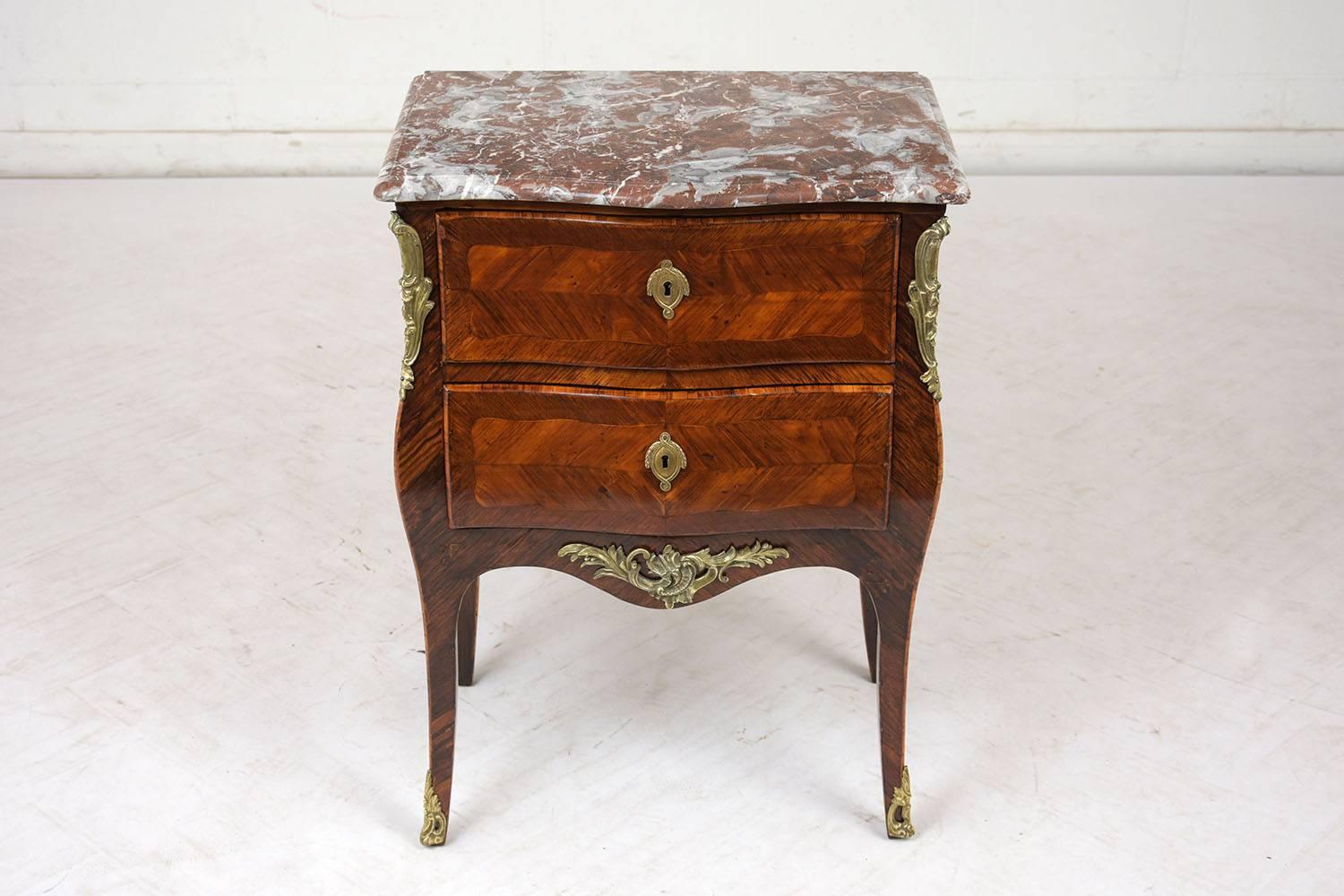 This Late 19th Century Louis XV Style Small Commode is made out of solid wood covered with veneers stained a rich mahogany color with a polished patina finish. The commode features its original beveled edge marble top that has a stunning rouge &