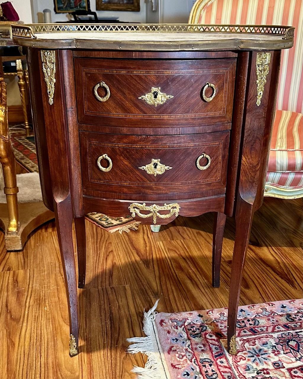 Late 19th Century Louis XVI Style Fruitwood Marquetry 2-Drawer Commode

This glowing kidney shaped fruitwood Marquetry commode in the Louis XVI style is richly adorned with gilded bronze ornaments. The Fine veneer marquetry work is a feature on all