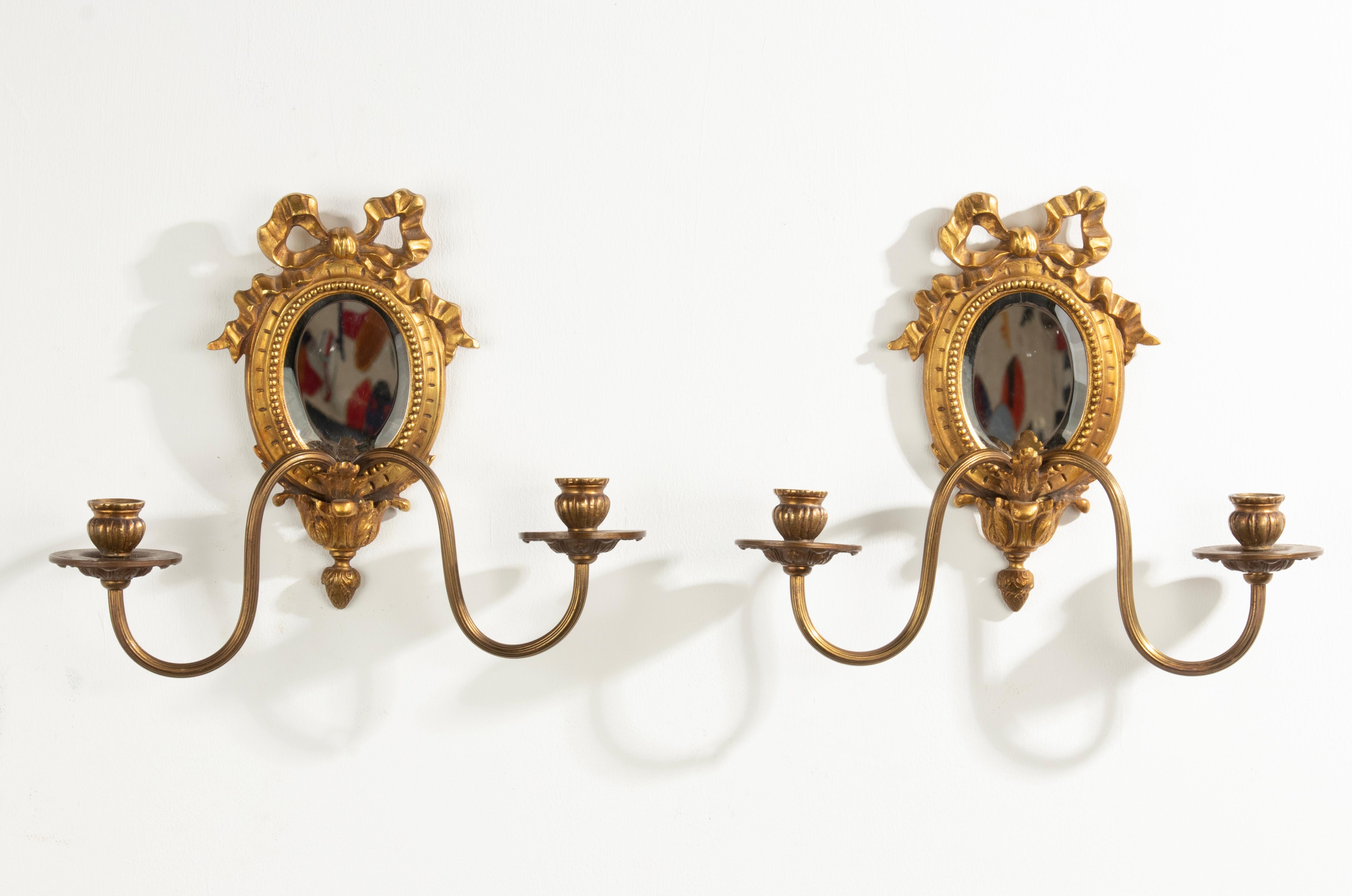 A pair of beautiful candle sconces. Made of Gilt bronze. All in Louis XVI style, with the classic ribbon and bow at the top and beaded rim. Inside the original beveled mirror glasses. Made In France, circa 1890-1900. They are in very good condition,