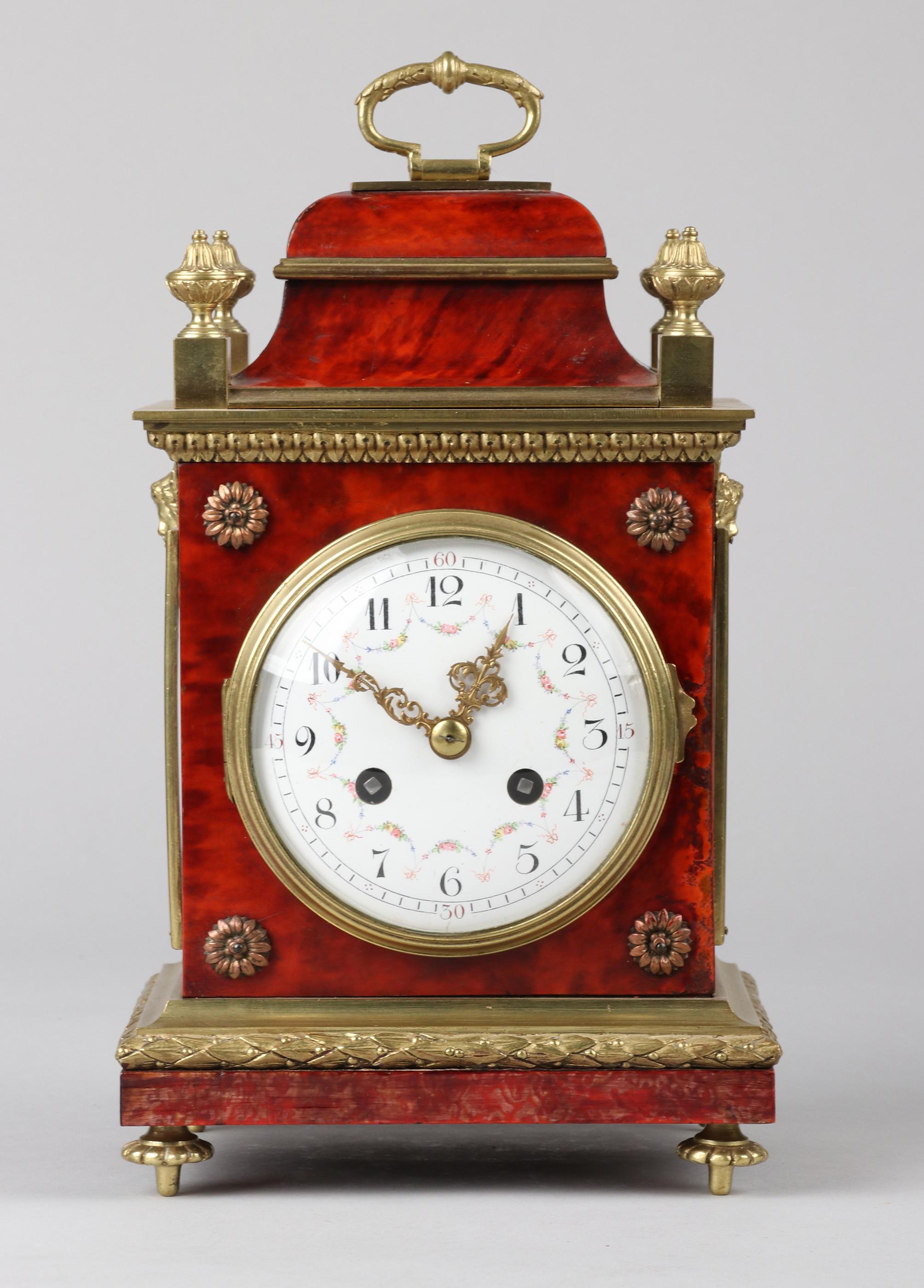 An antique French officer's travel clock, made in the Louis XVI style. The case is made of wood, veneered with  imitation tortoiseshelll, which is original. Synthetic tortoise has been used since 1870. The sides have glass panels with gilt bronze