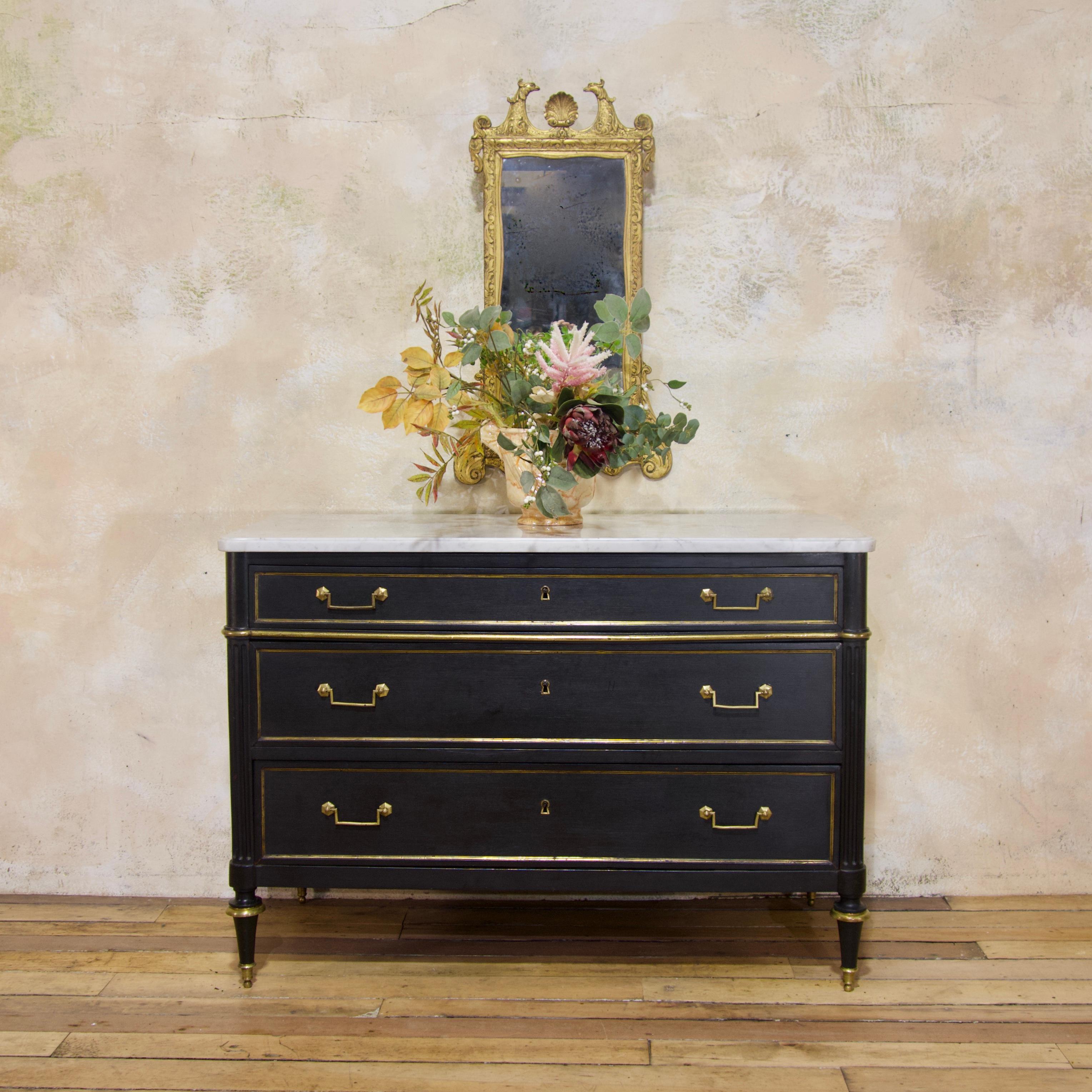 A large scale, late 19th century Louis XVI style three-drawer commode.  Of elegant proportions, featuring original brass mounts and thick Carrara marble top - displaying a beveled edge and rounded front corners. Raised on turned feet, with brass