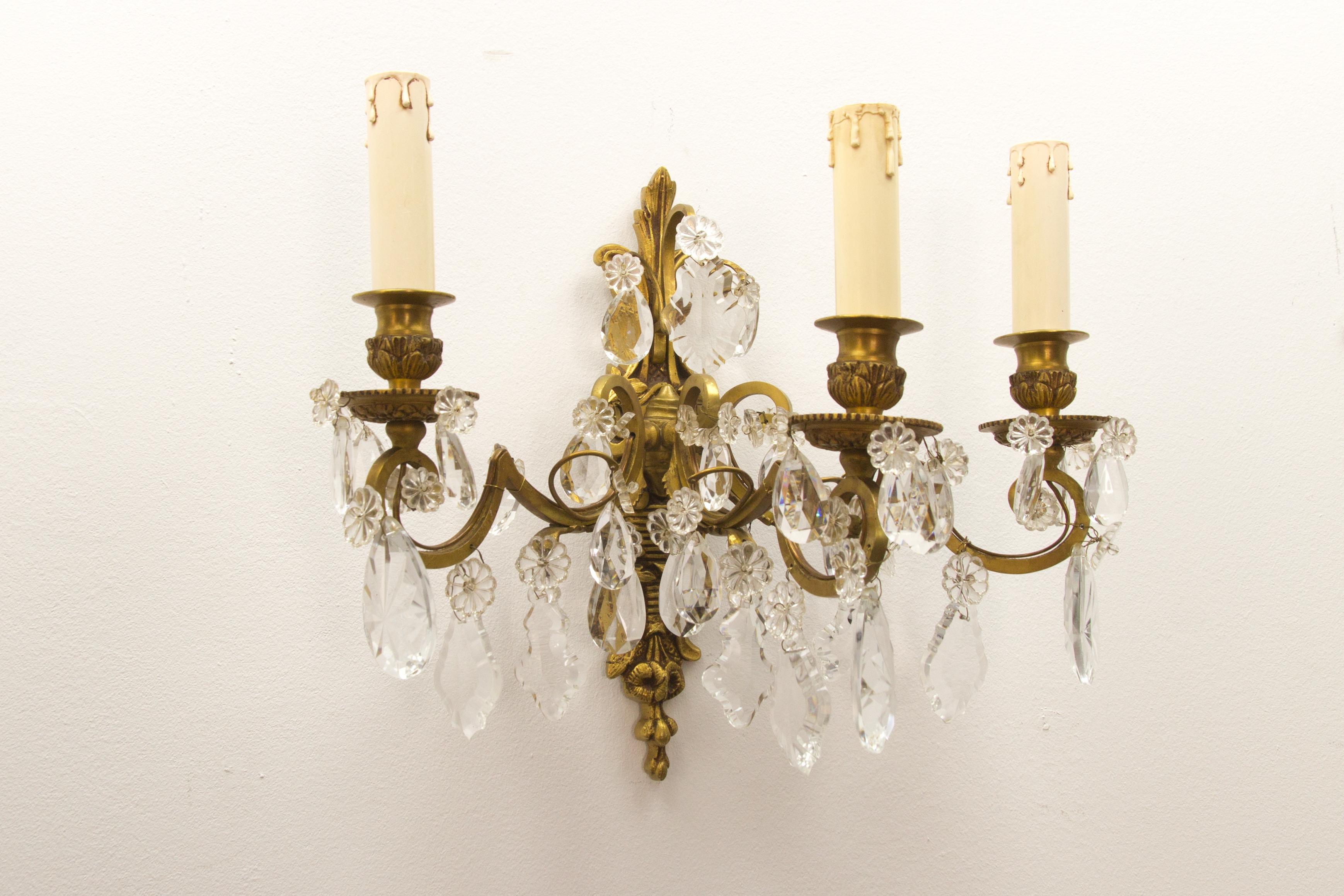 Exquisite French Louis XVI style late 19th-century three-light wall sconce. Originally crafted for 3 candles, this antique wall applique has been electrified. Made of bronze with foliate and floral motifs and decorated with multifaceted and shaped