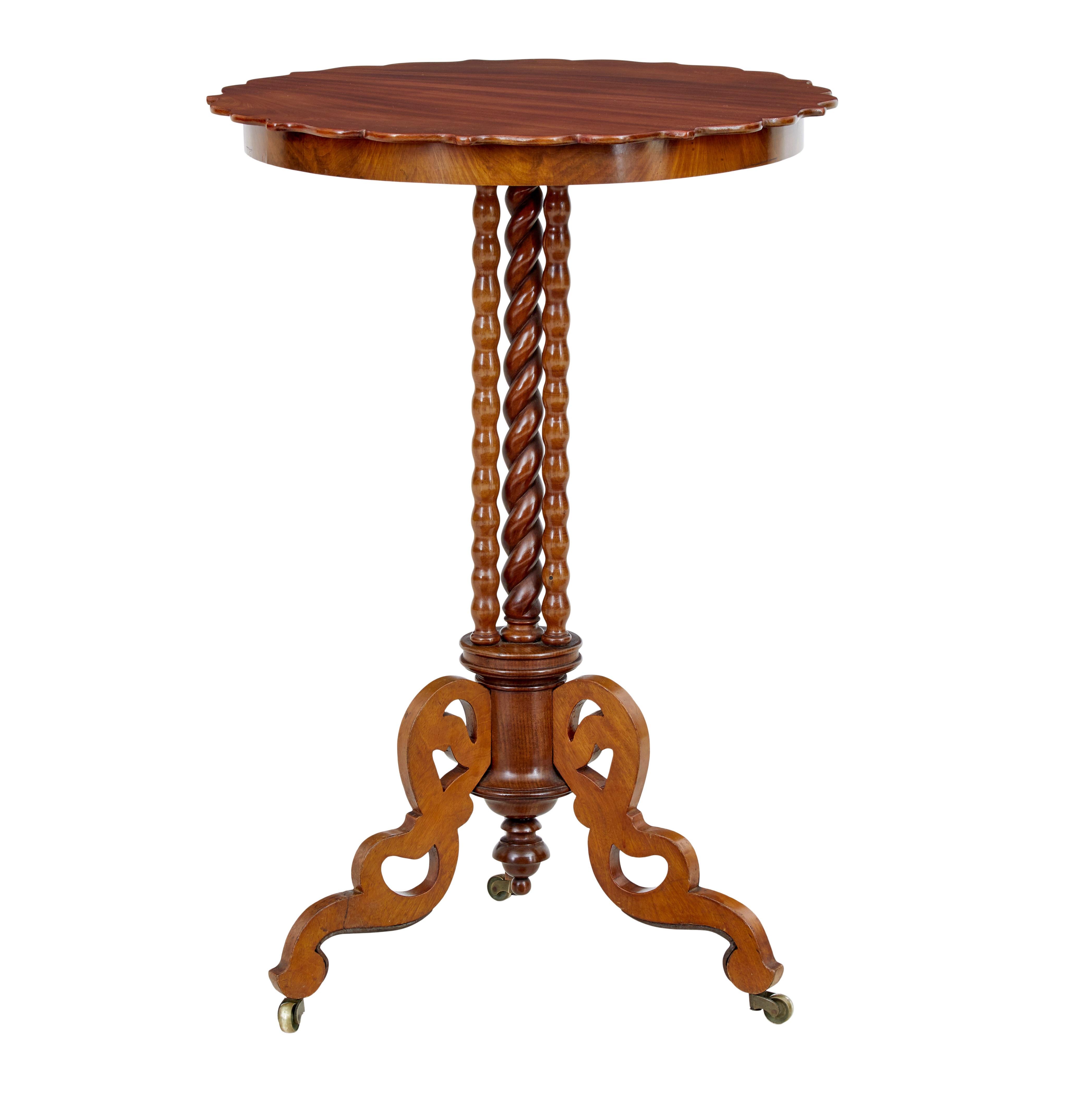 Late 19th century mahogany bobbin turned occasional table circa 1890.

Scalloped shaped circular top, which sits on a stem of 1 barley twist stem surrounded by a further 3 barley twist supports, all supported on 3 fret cut scrolling legs and brass