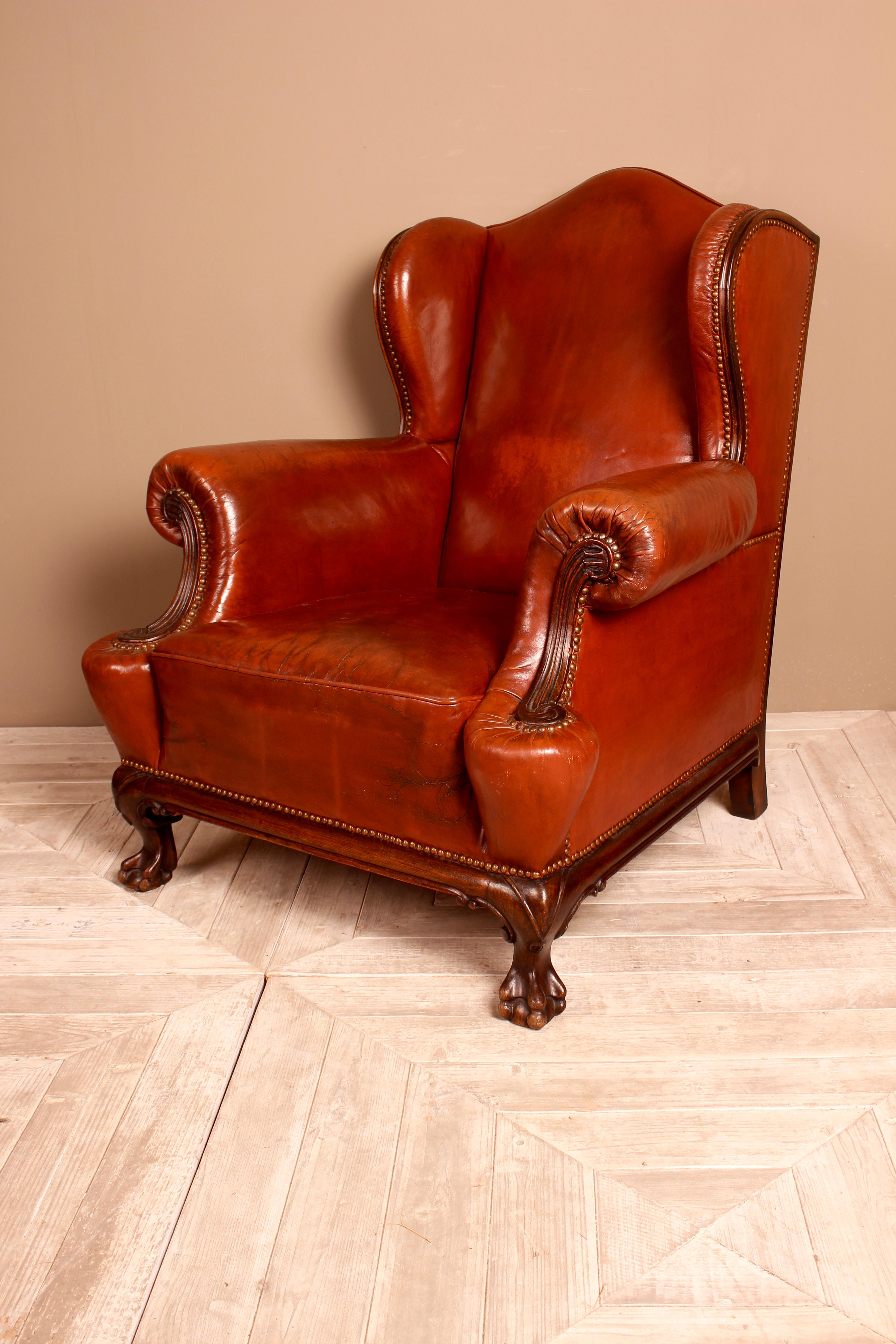 A Classic late 19th century mahogany leather wingback armchair. Traditionally made with solid wood frame, leather and stud detail and sprung seat. With deep wingback frame, scroll arms and wooden show frame. Standing on an attractive lower show