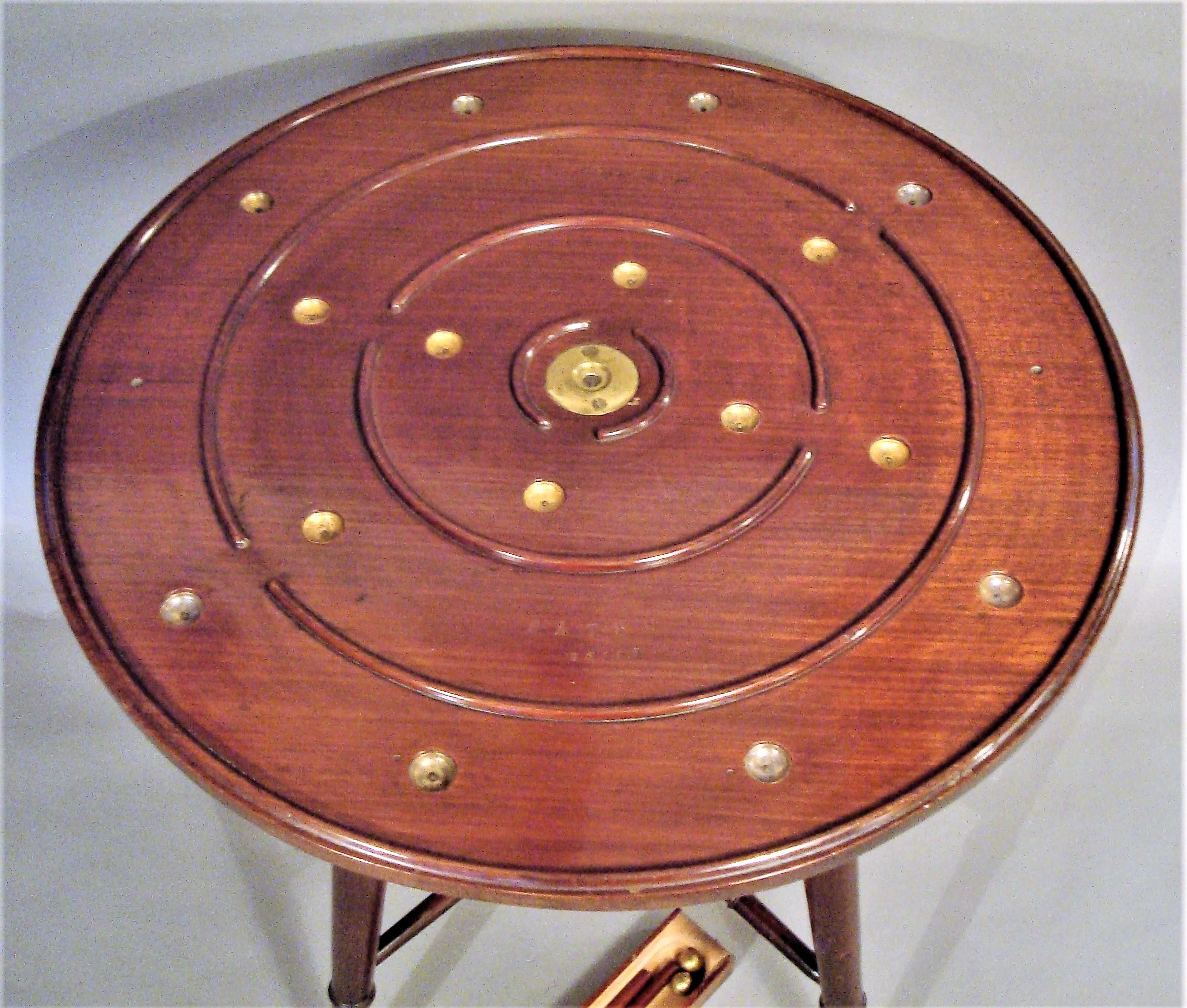 A rare late 19th century mahogany golf game table; this interesting table by Henry D Booth, stamped Parlour Golf Patent; the revolving circular top have a lane golf course with 16 brass holes and 2 opposing start positions. With a concealed drawer