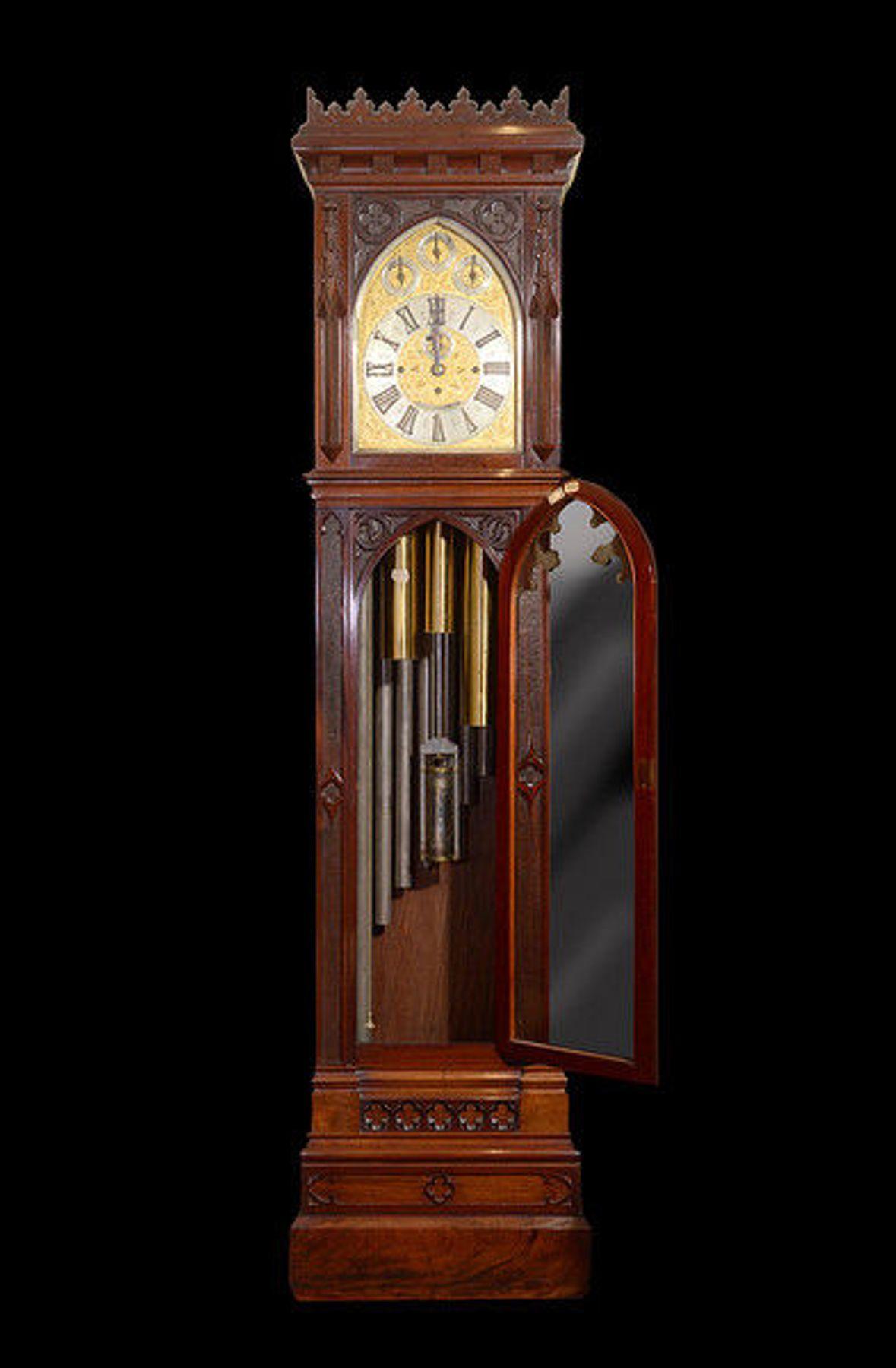 An impressive late 19th century carved mahogany eight day, Gothic revival, longcase clock of extra large proportions.
The castellated pediment above the Gothic arched dial with a silvered chapter ring and subsidiary silent/strike and silent/chime
