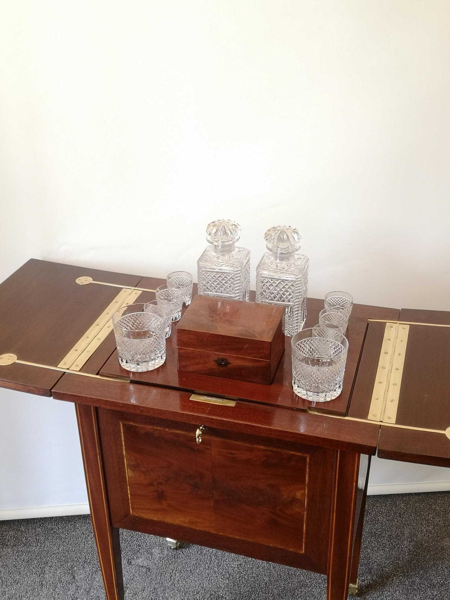 A late 19th century mahogany 'surprise bar'. As you open the top, a tray pops up consisting of, six shot glasses, two tumblers, two decanters, all in cut crystal and a mahogany box, with good quality brass hinges. The mahogany case with boxwood
