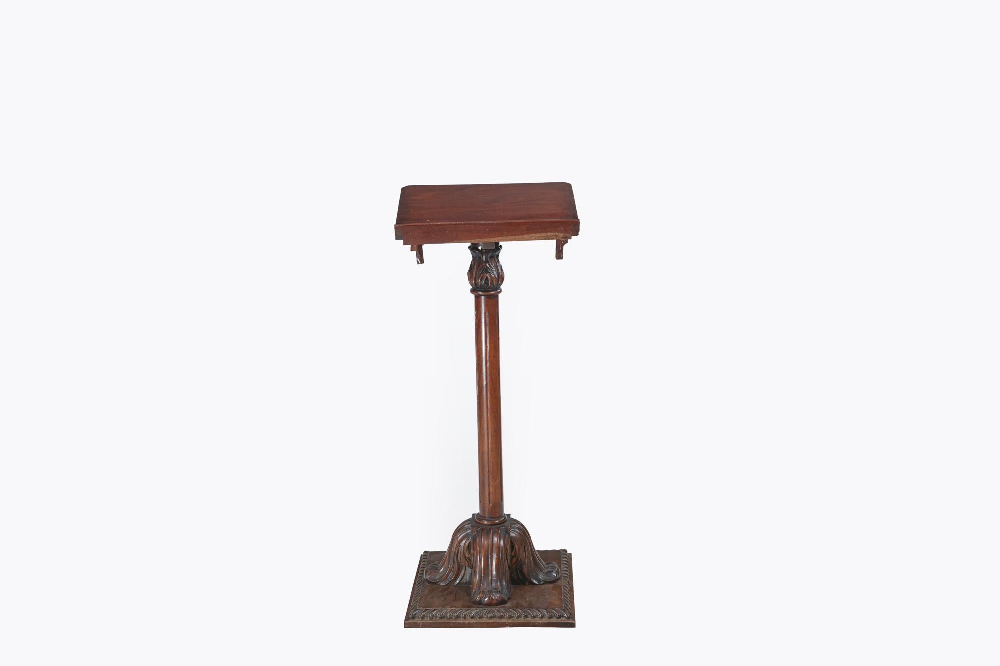 Late 19th Century mahogany lectern with a carved frieze in the form of a draped cloth, supported by a fluted stem which terminates in a scroll quatrefoil base and square platform.