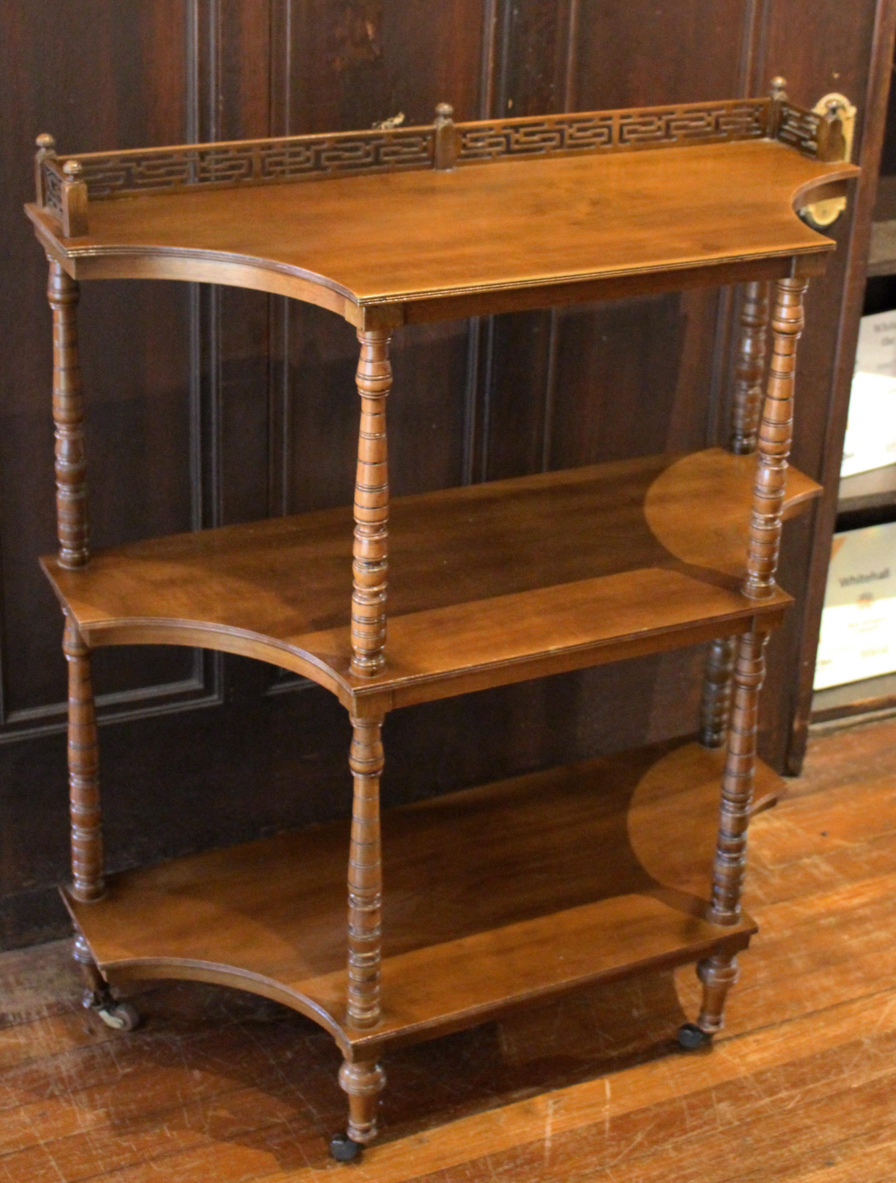 Late 19th century shaped 3-tier butler's buffet or etagere, mahogany, English. Concave sides ideal for a hall and many other spaces. Fret work top tier gallery with finials. Well-turned uprights with extensive incised and turned rings. Measures: 33
