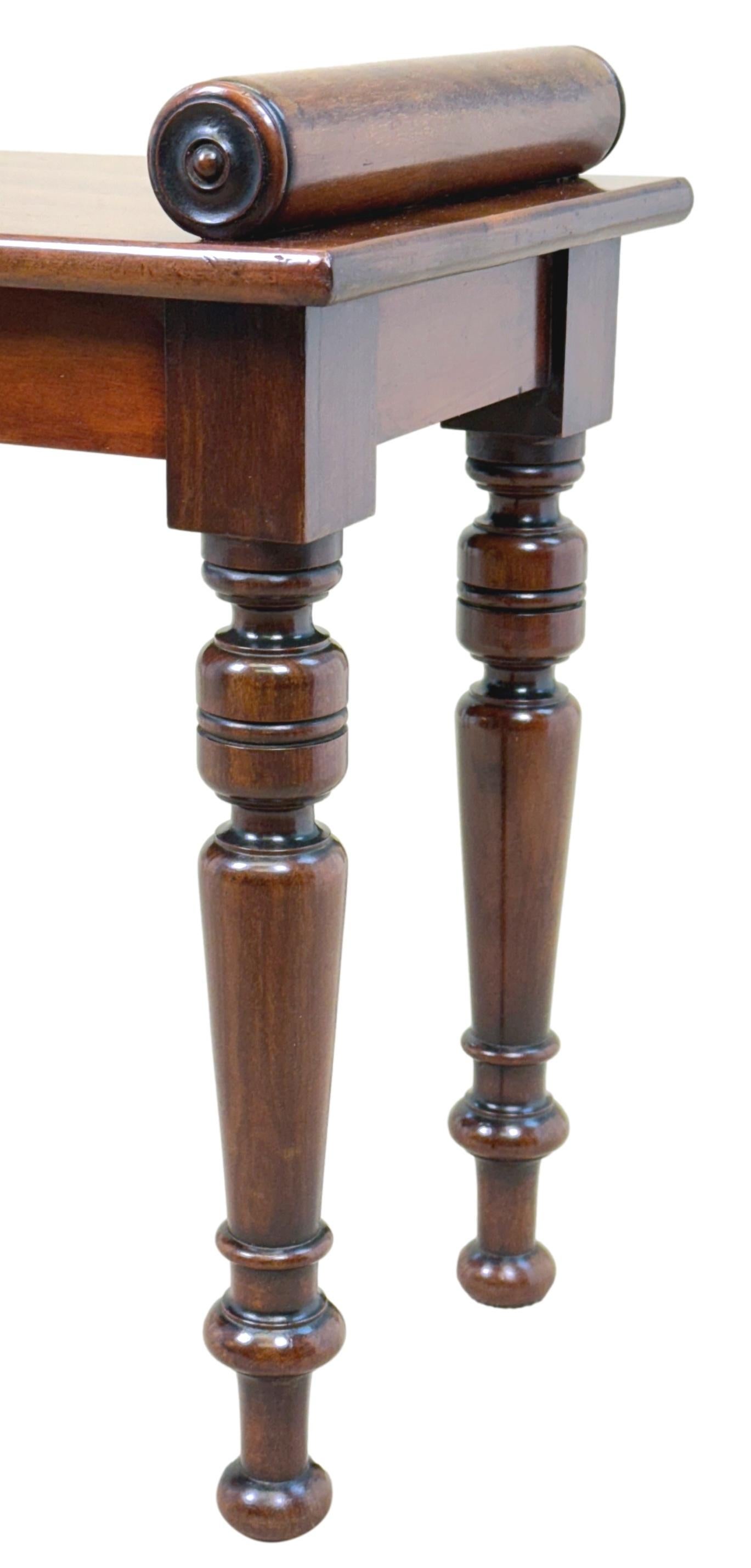 A Very Good Quality Late 19th Century Mahogany Window Seat, Or Hall Bench, Of Relatively Small Proportions, Having Well Figured Rectangular Top With Turned Rolls To Each End, Raised On Elegant Ring Turned Legs.

Hall benches from the 19th century
