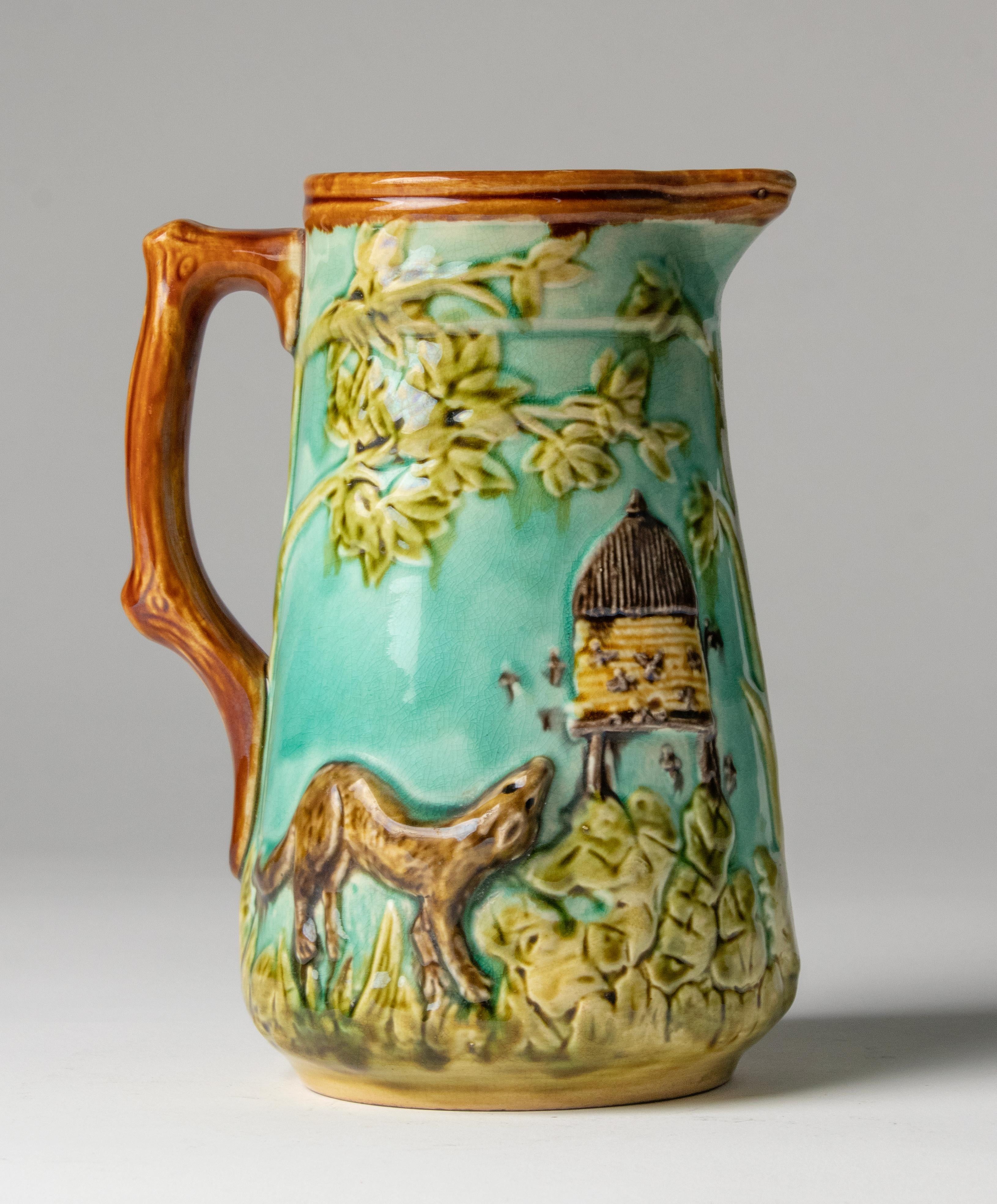 Beautiful large majolica jug. The jug has a lively and colorful decor, with a dog curiously looking at the beehive.
Clearly marked on the bottom: Mouzin Lecat & Cie. Nimy.
The jug is in good condition.