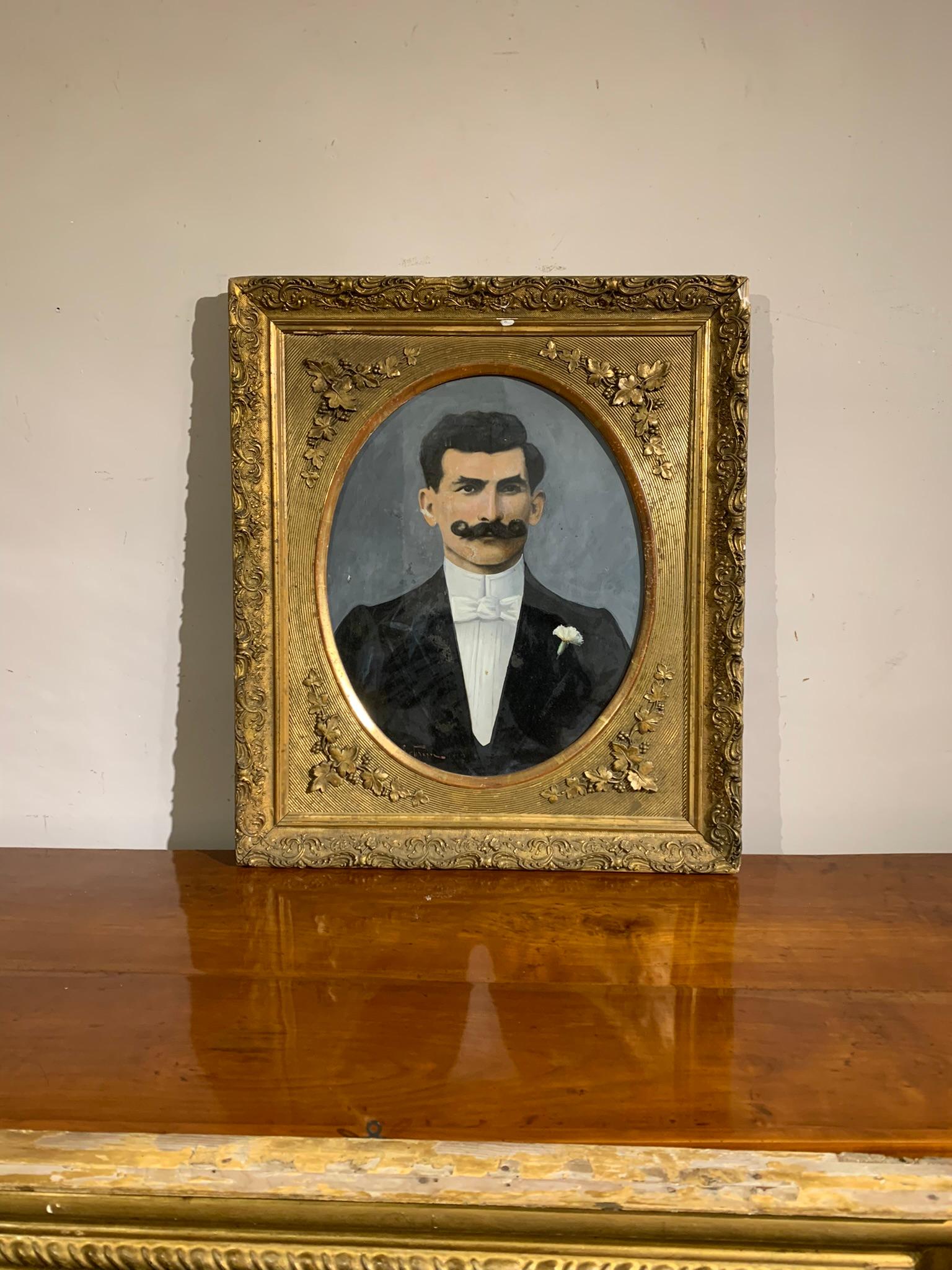 Portrait d'un homme à la moustache torsadée, dans le costume sombre typique de l'époque Art nouveau de la fin du XIXe siècle. Cadre de tablette doré, avec décorations florales.
Technique de détrempe sur carton, signature non identifiable mais