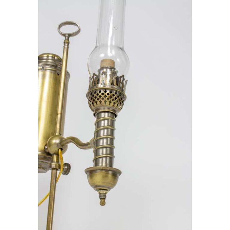 A nickel and brass student lamp with height adjustable arm. Includes original glass chimney. Oil reservoir has a spiral design, showing a lovely mixed metal effect where the nickel plate has worn. Carefully electrified, and newly rewired. 60 Watt