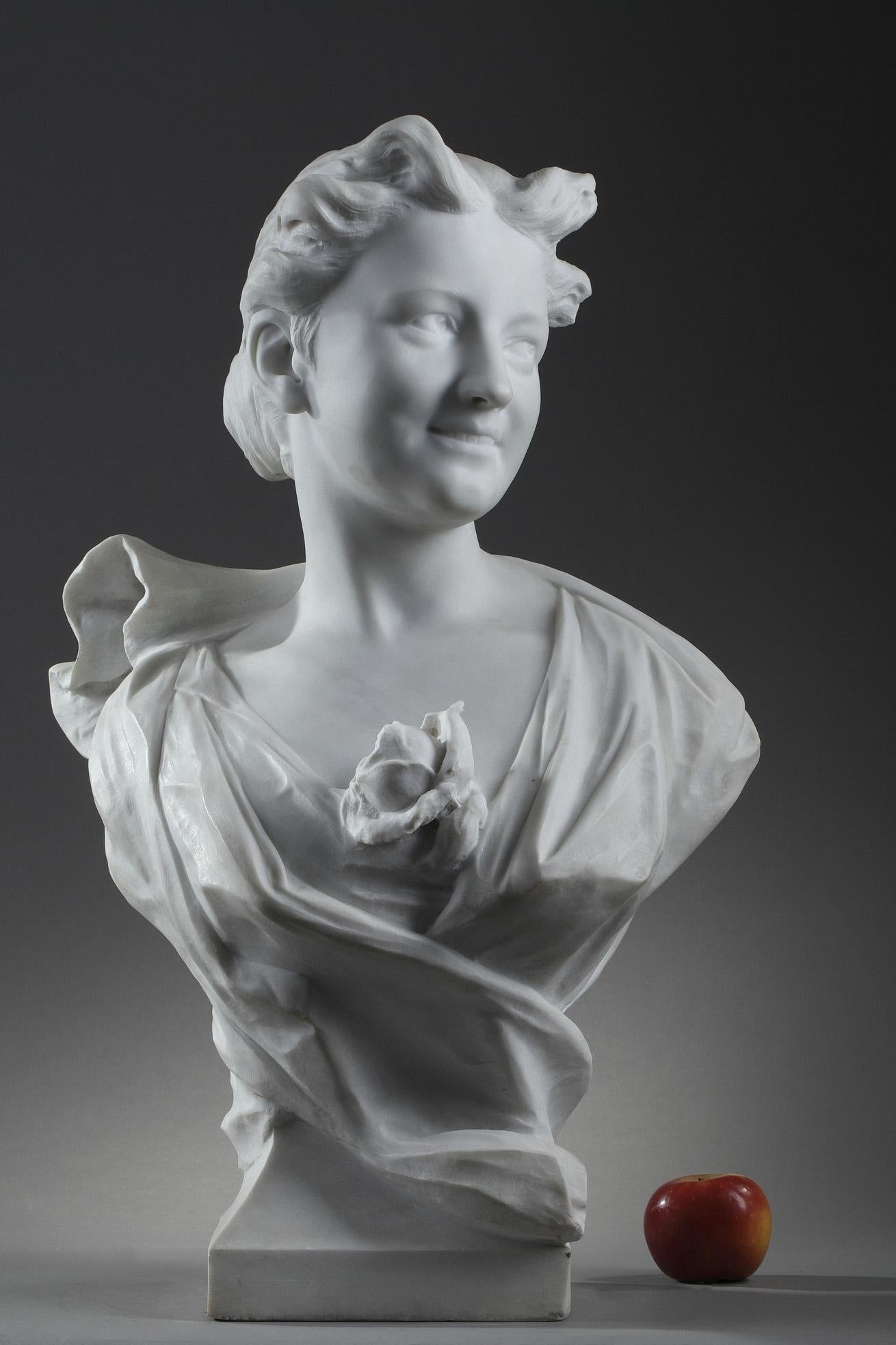 Late 19th century marble sculpture in the taste of Albert Carrier-Belleuse (1824-1887), featuring the bust of a young woman wearing a dress decorated with flower. Her curly hair is carefully put up in a bun. Her smiling and expressive face is turned