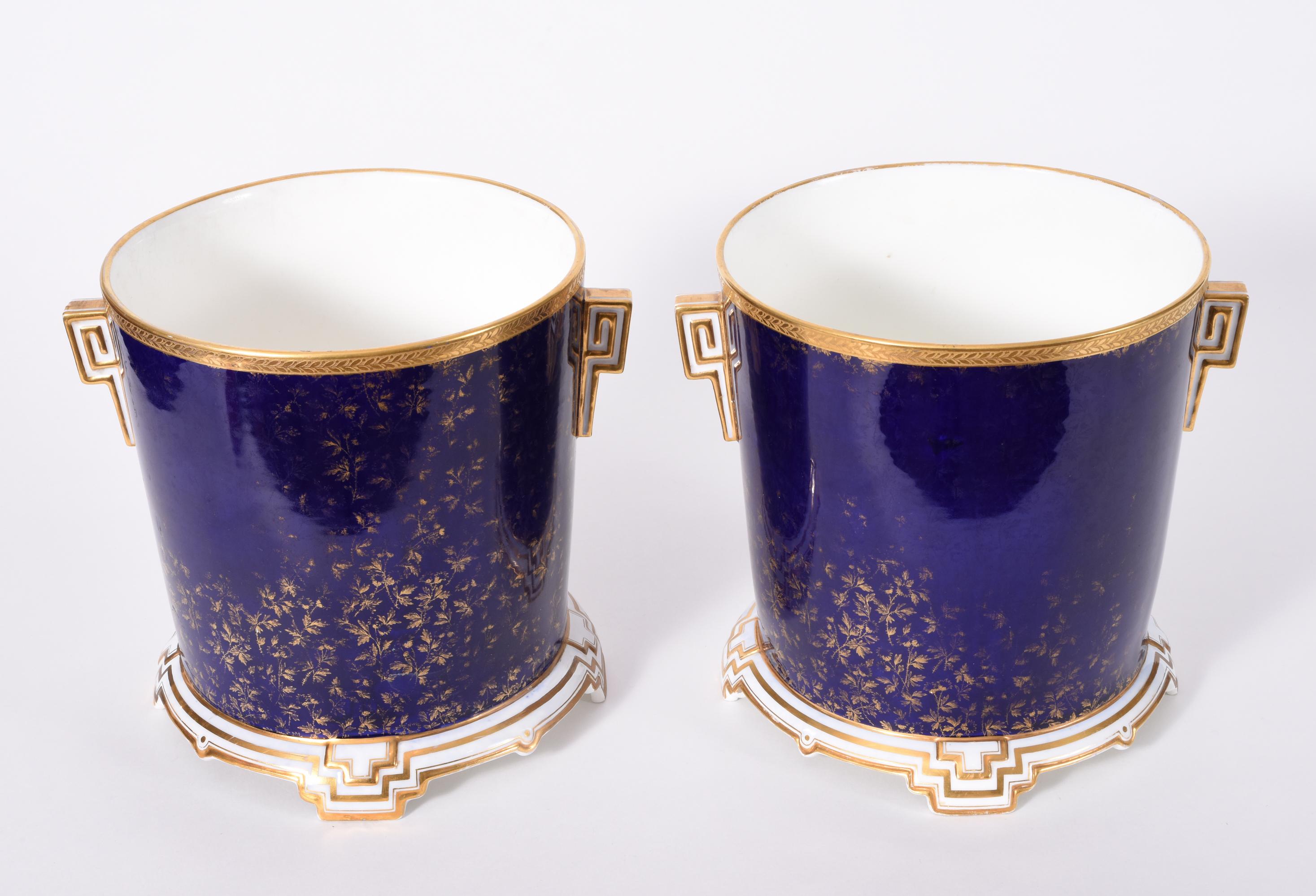 Late 19th century matching pair of English porcelain Wedgwood wine coolers / ice bucket. These coolers are just exquisite with gold-plated design details and in excellent antique condition. Maker's mark undersigned . Each cooler measure about 8.4