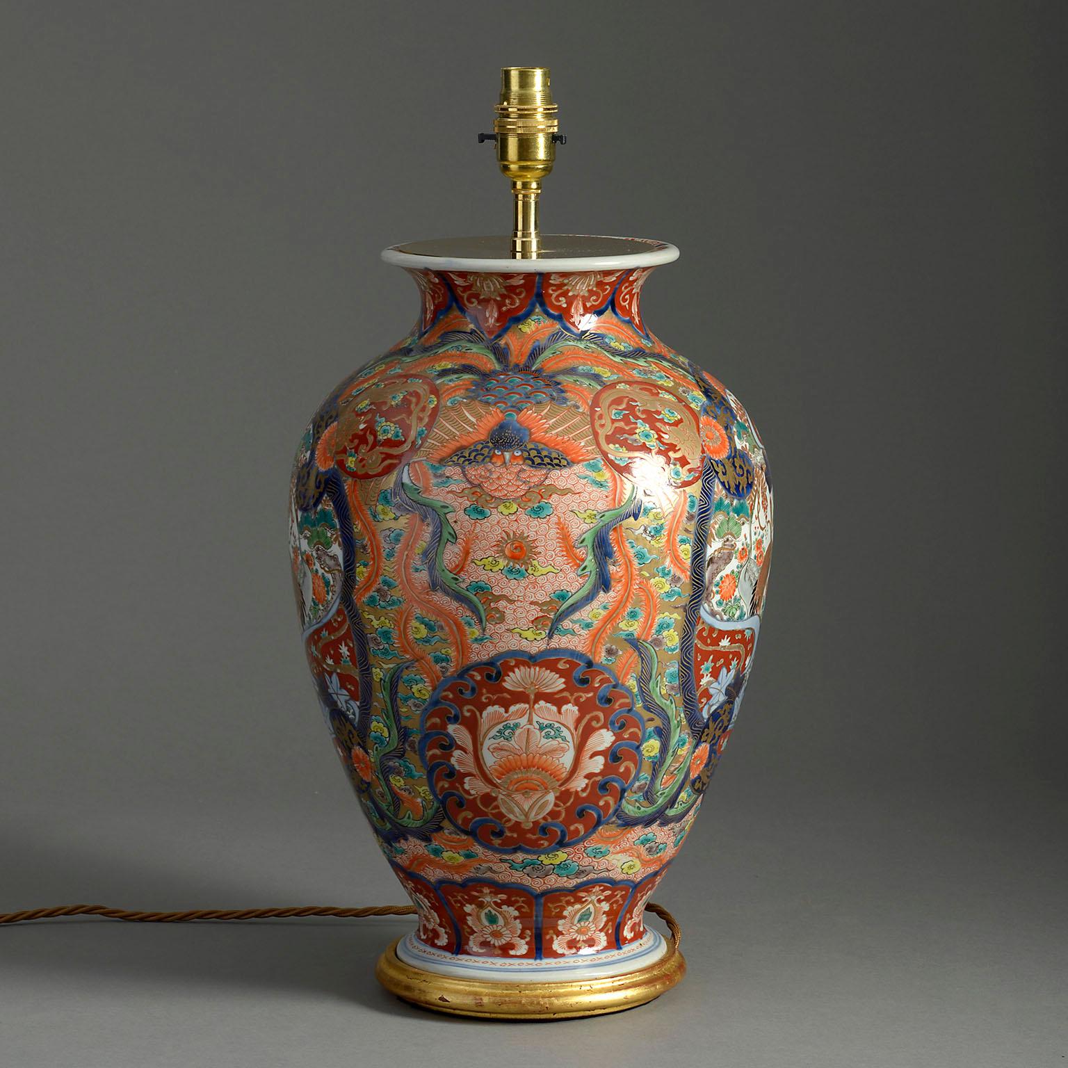 A late nineteenth century Meiji Period Imari vase, decorated in the traditional manner with flowers, foliage and bird in rich red, blue, green and gold glazes. Now mounted on a hand-turned giltwood base as a lamp.

Dimensions refer to porcelain