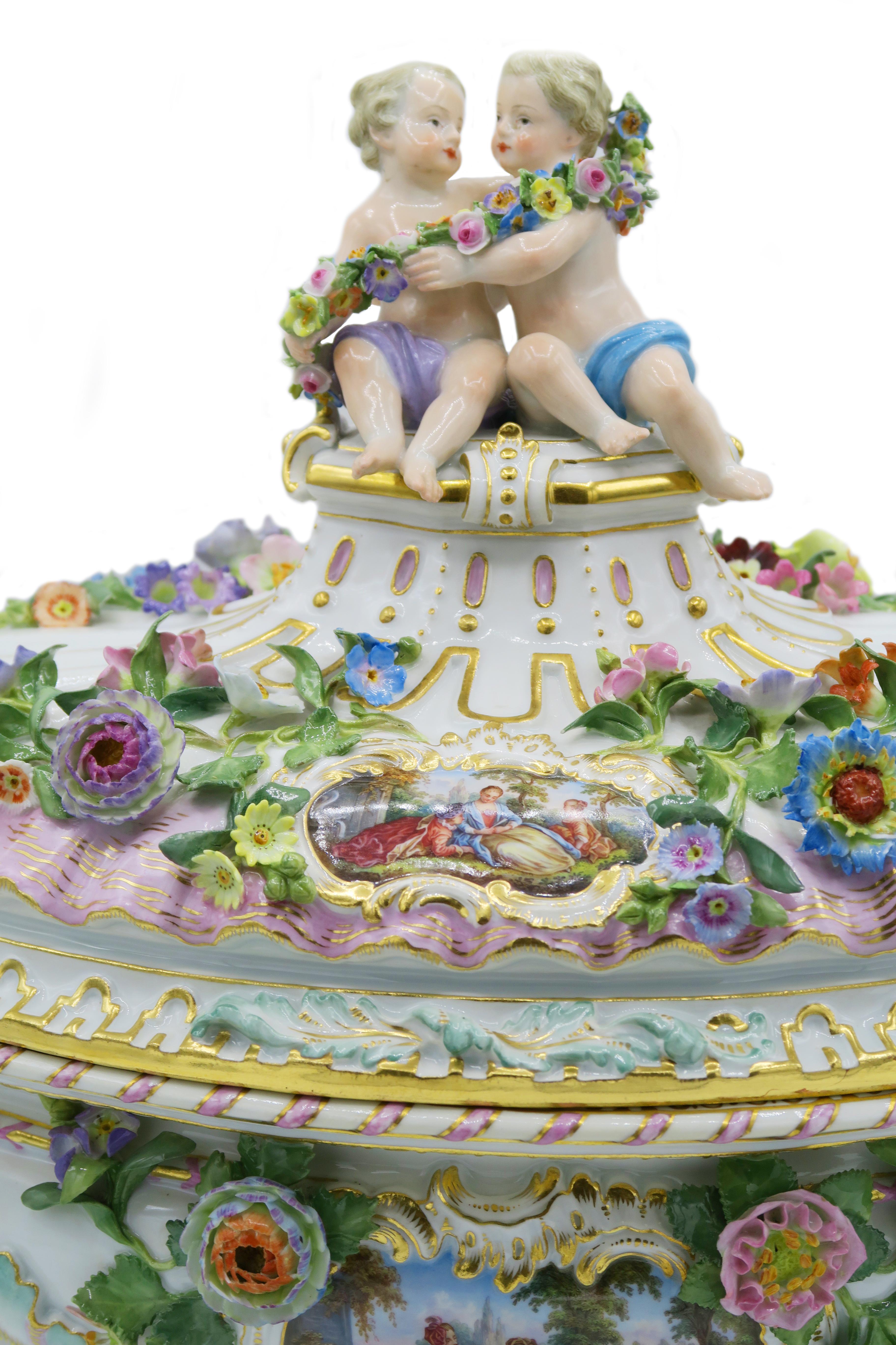 Late 19th century Meissen large tureen

Finely detailed and vivid colored embossed flower garlands extend throughout the tureen with a gilt band borders. On the wall of the bowl depicts Watteau-esque pastoral scene and two cute children on the