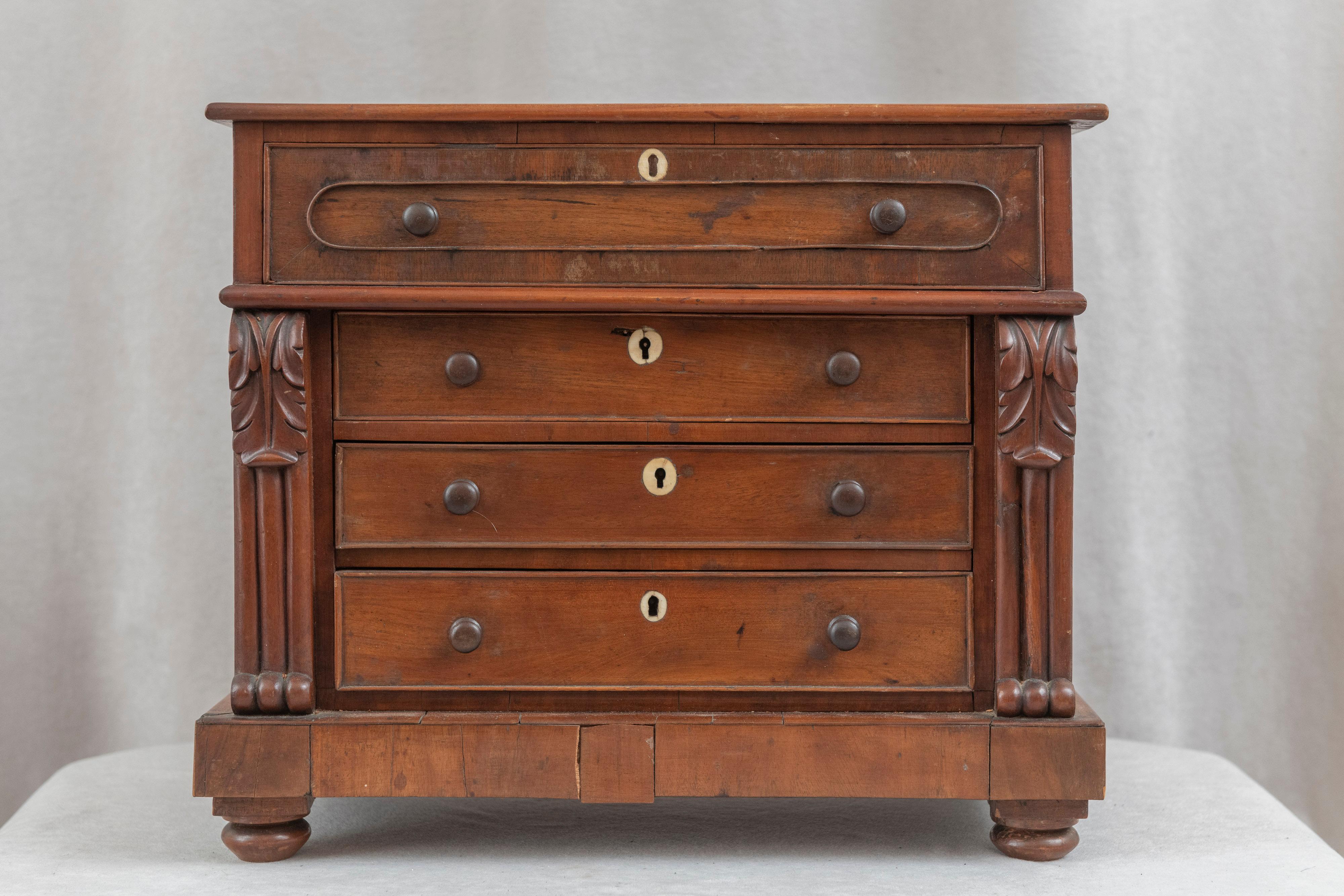 This lovely little mahogany dresser can solve much of one's needs without taking up a lot of space. Hand carved with the original wooden knobs and as an added bonus, bone keyhole escutcheons. Well made, rich in color, nicely finished, and that