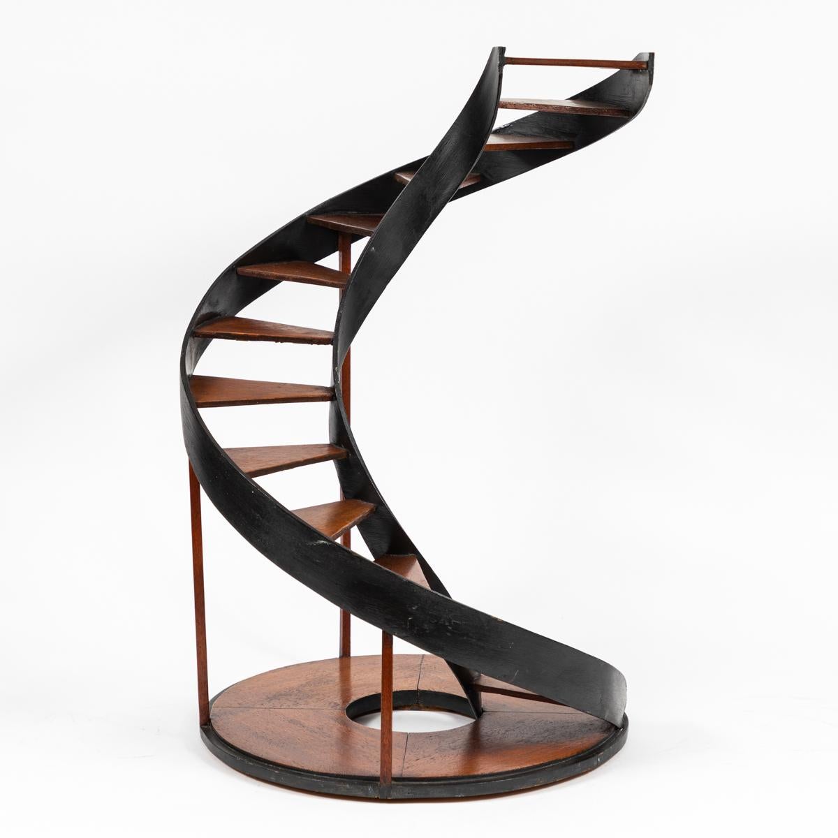 Late 19th-century industrial model of spiral staircase. Both understated and a conversation piece, the steps and circular base are a warm, honey-toned wood that complements the dark metal rails. Charged with movement and industrial grace.

France,