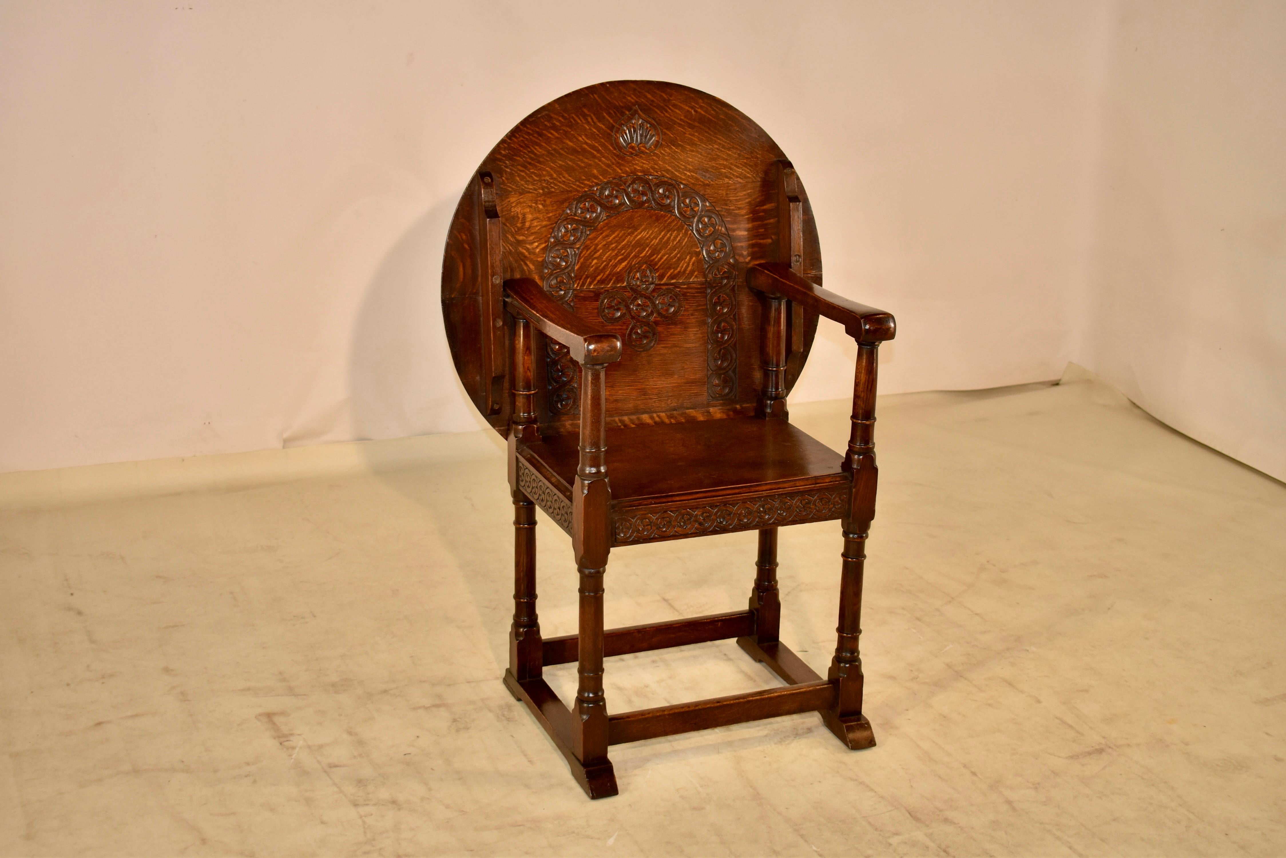 Late 19th century oak Monk's seat from England. When the top is up, it can be used for comfortable seating. The seat back has hand carved details for added interest. The seat can then be converted easily into a table top by sliding the back of the