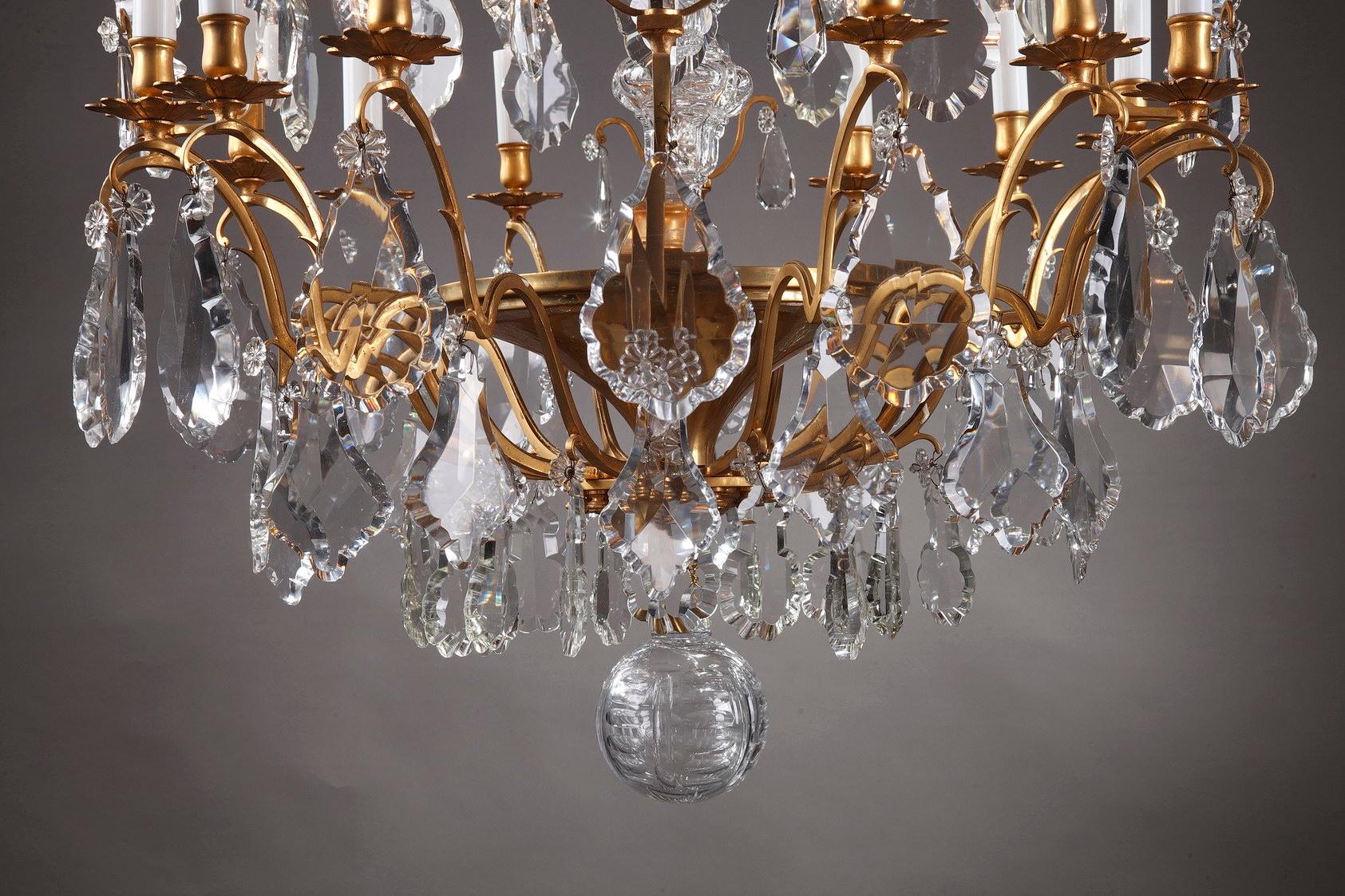 Very large late 19th century crystal chandelier. This exquisit ceiling light features oversized faceted drops, flowers and luminous daggers of fine cut-crystal. The 12 lights of this fixture are supported by scrolling branches cast in ormolu, or
