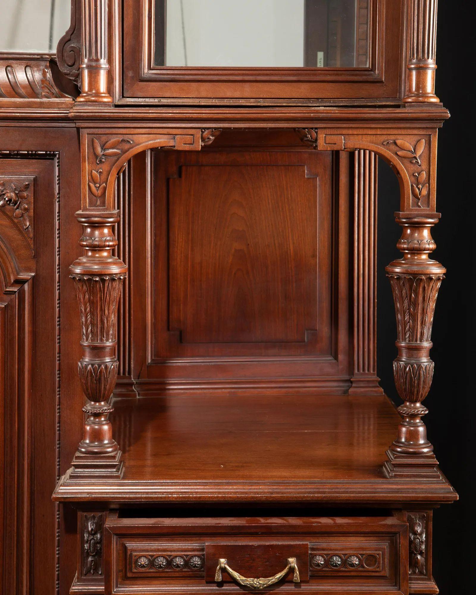 Late 19th century monumental French buffet.
 
Carved walnut with crest, ribbon and garland details, three inset Wedgwood porcelain plaques, glazed doors, and mirrored back.
 
Dimensions:
 
111