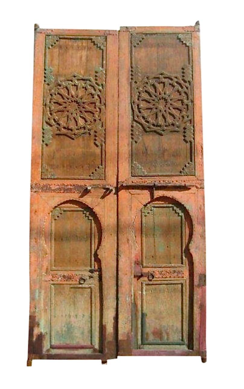 Magical pair of huge painted Moroccan Riad courtyard doors. Install them as doors in your home or use them as decorative pieces. Hand carved and wonderfully weathered. 