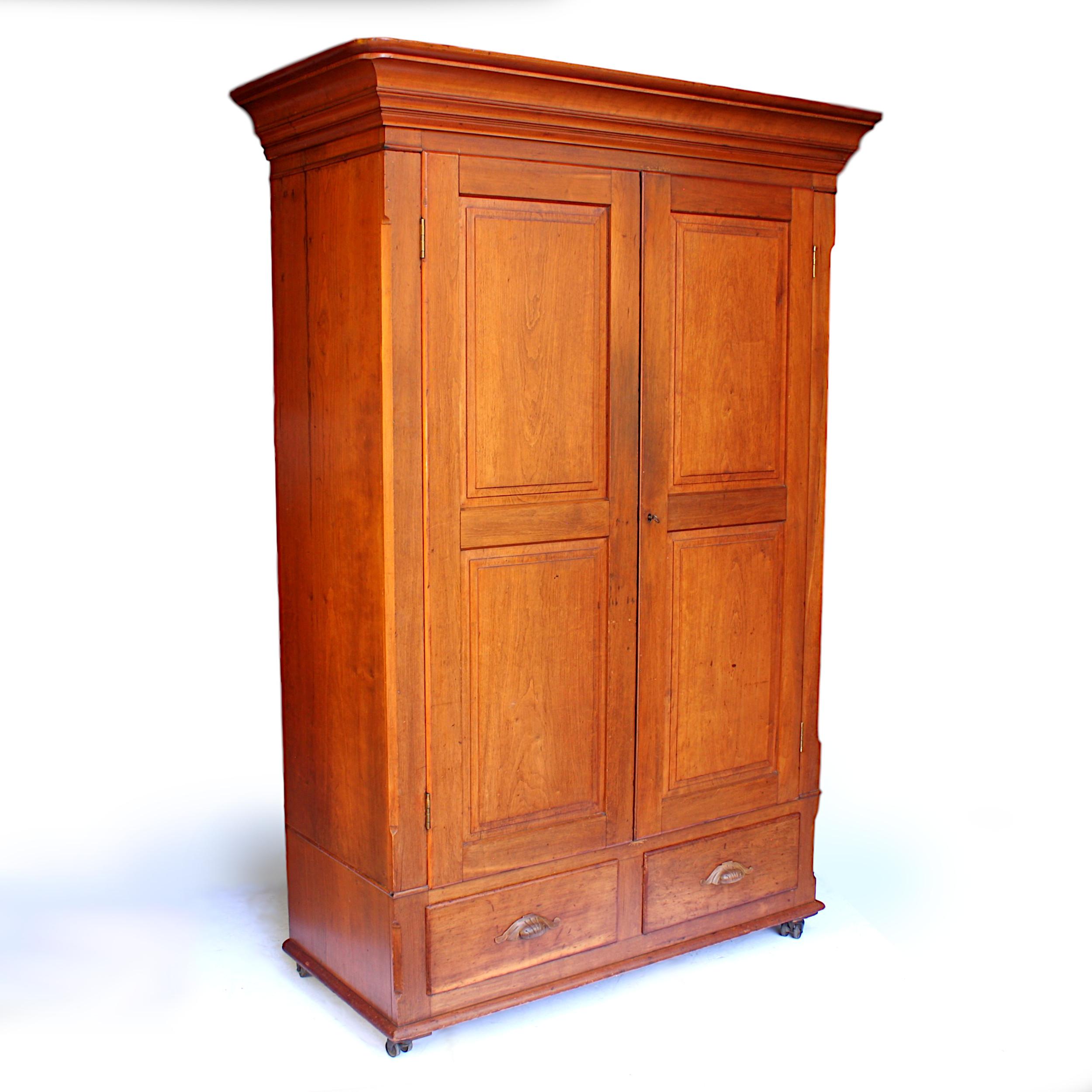 Wonderful 1880s neoclassical wardrobe with many unique features!

Features include:

- Solid cherrywood construction
- Swing-out hangers
- Original double-wheel steel casters
- Knock-down/collapsible design
- Secret compartment hidden under