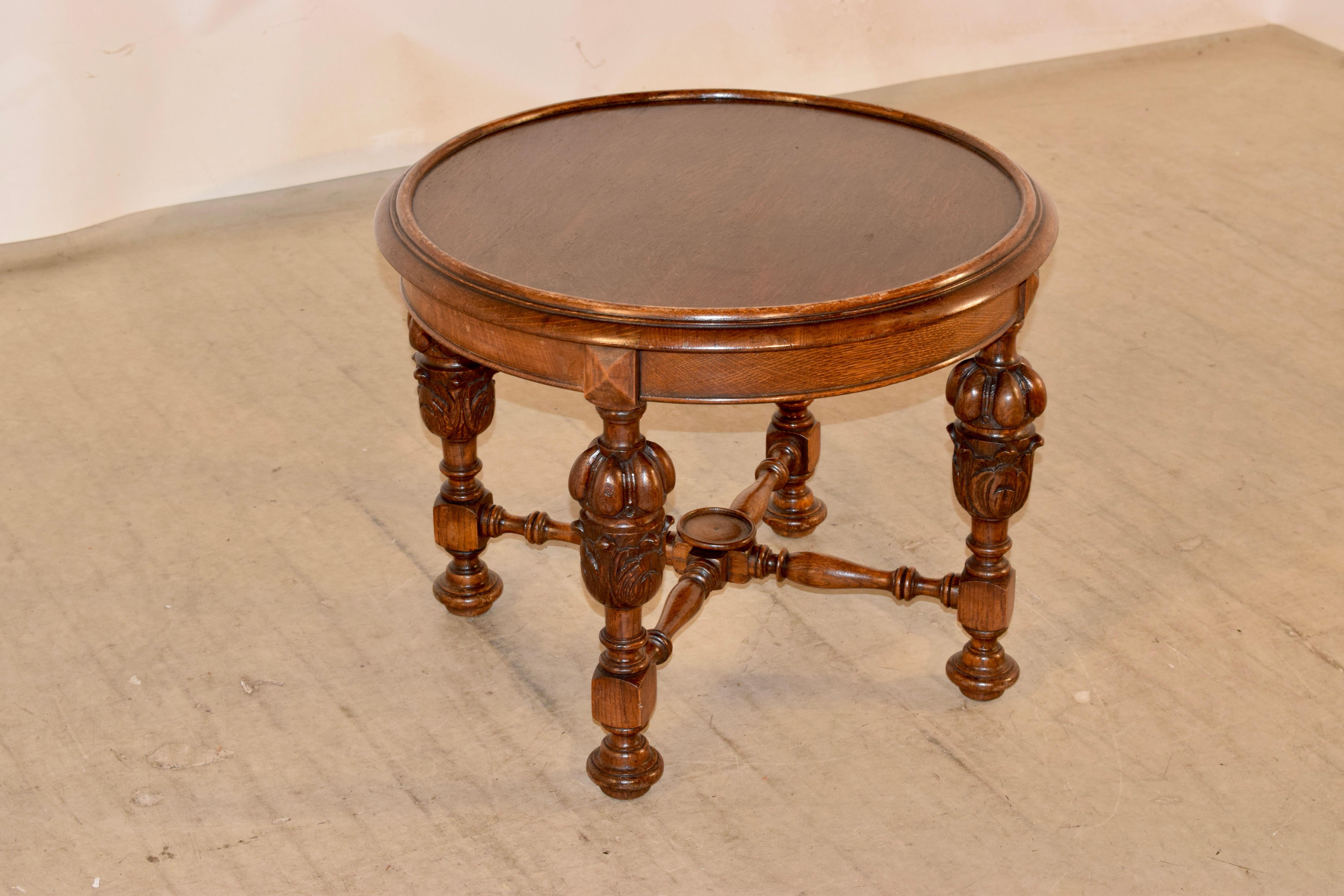 Late 19th century oak coffee table from England with a dish shaped top which has a wonderfully hand molded edge and follows down to a simple apron with a molded edge and supported on hand turned and carved bulbous legs, joined by hand turned