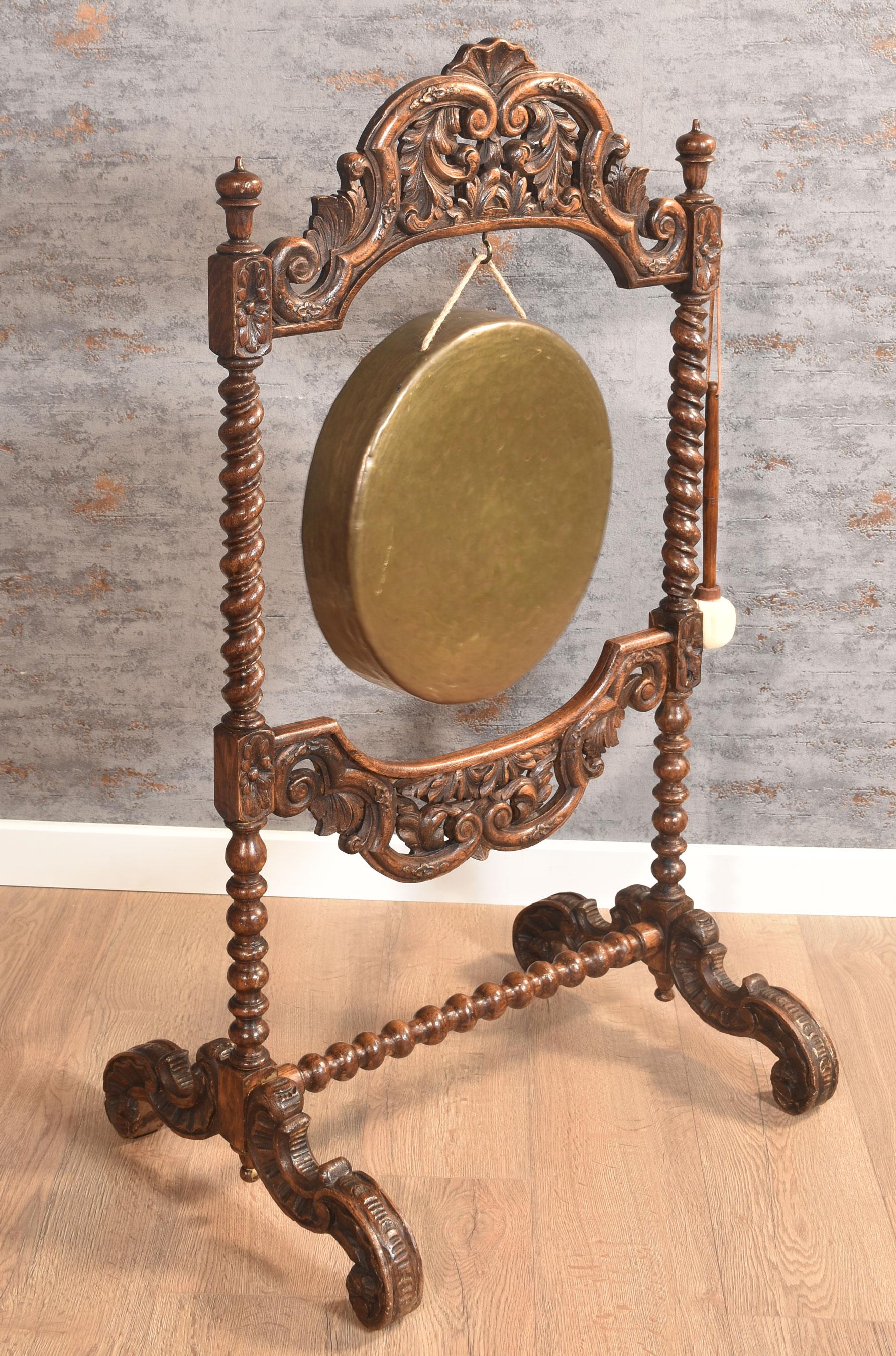 Gong et batteur en chêne du 19e siècle. Le plateau arqué est orné d'une décoration sculptée au-dessus des supports en torsion d'orge. Au centre, un gong en laiton est suspendu. Le tout reposant sur des pieds à enroulement.
Dimensions
Hauteur 49,5