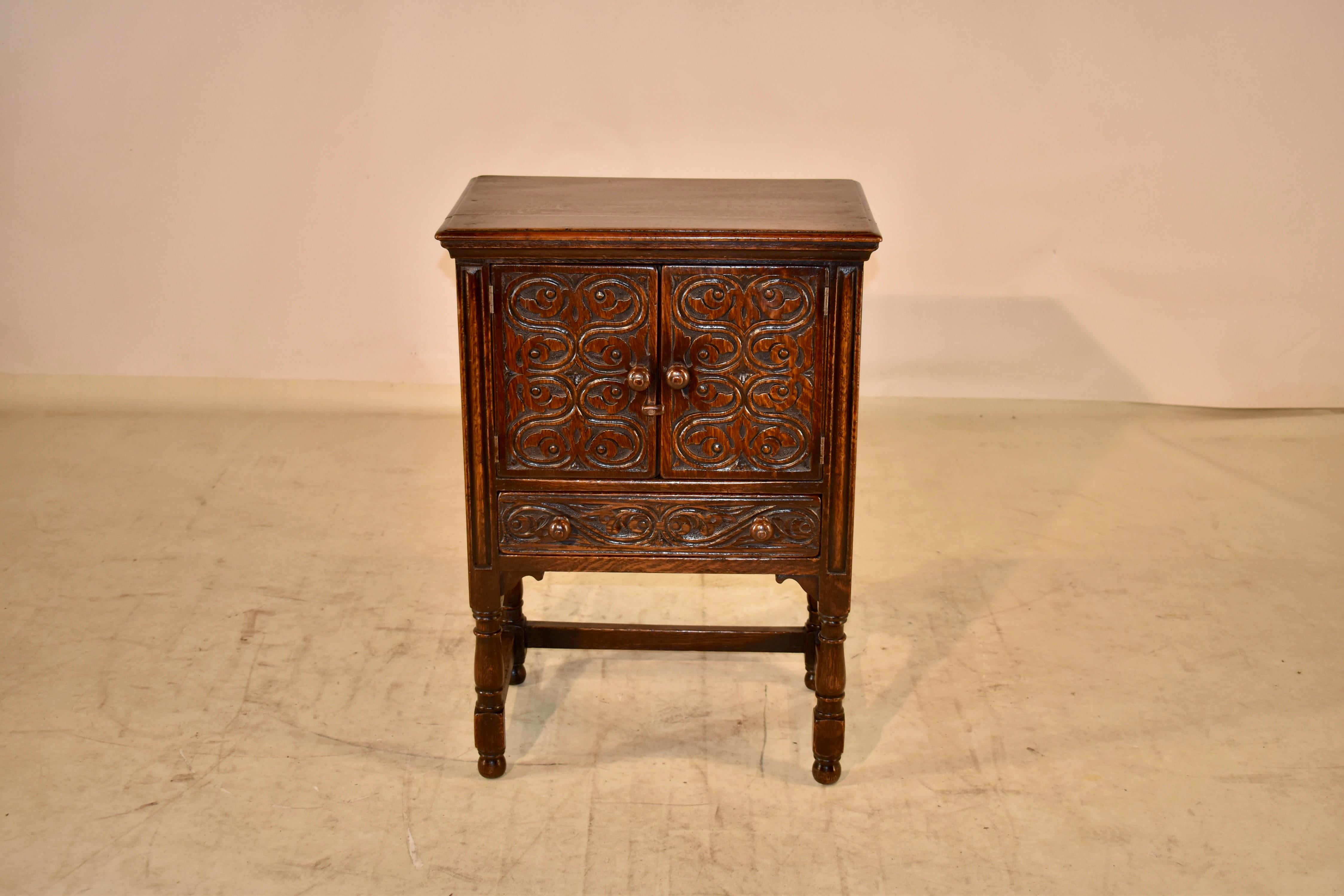 Late 19th century oak side table from England. The table is in the form of a small cupboard, which would be excellent for storage beside a chair or sofa. The top has a beveled edge, following down to paneled sides and two doors in the front, both of