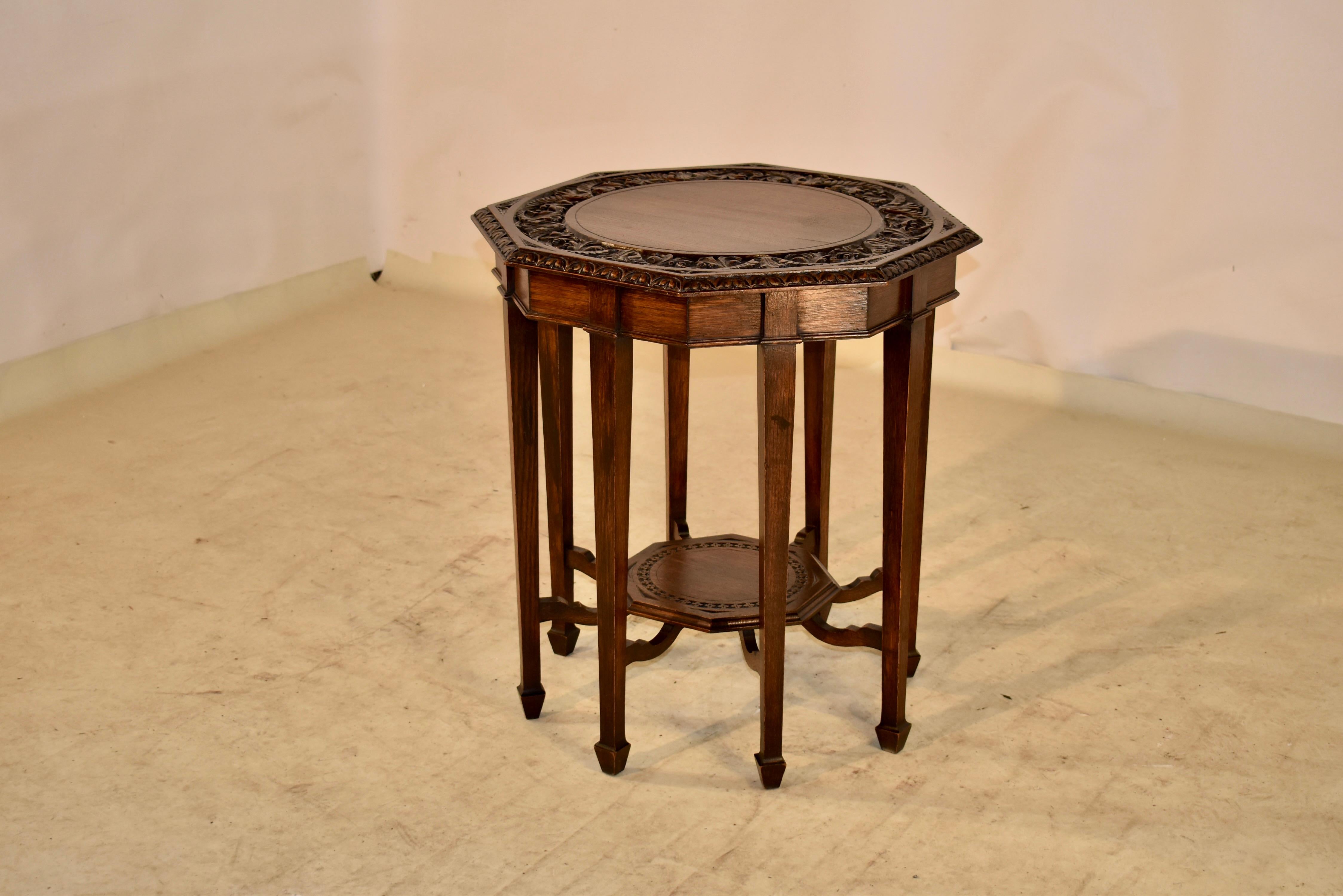 Very unusual late 19th century oak side table from England.  The table is a great form.  It has an octagonal top, which is beveled and carved around the edge, and is surrounding a hand carved decorated band as well.  The apron has a lovely molded