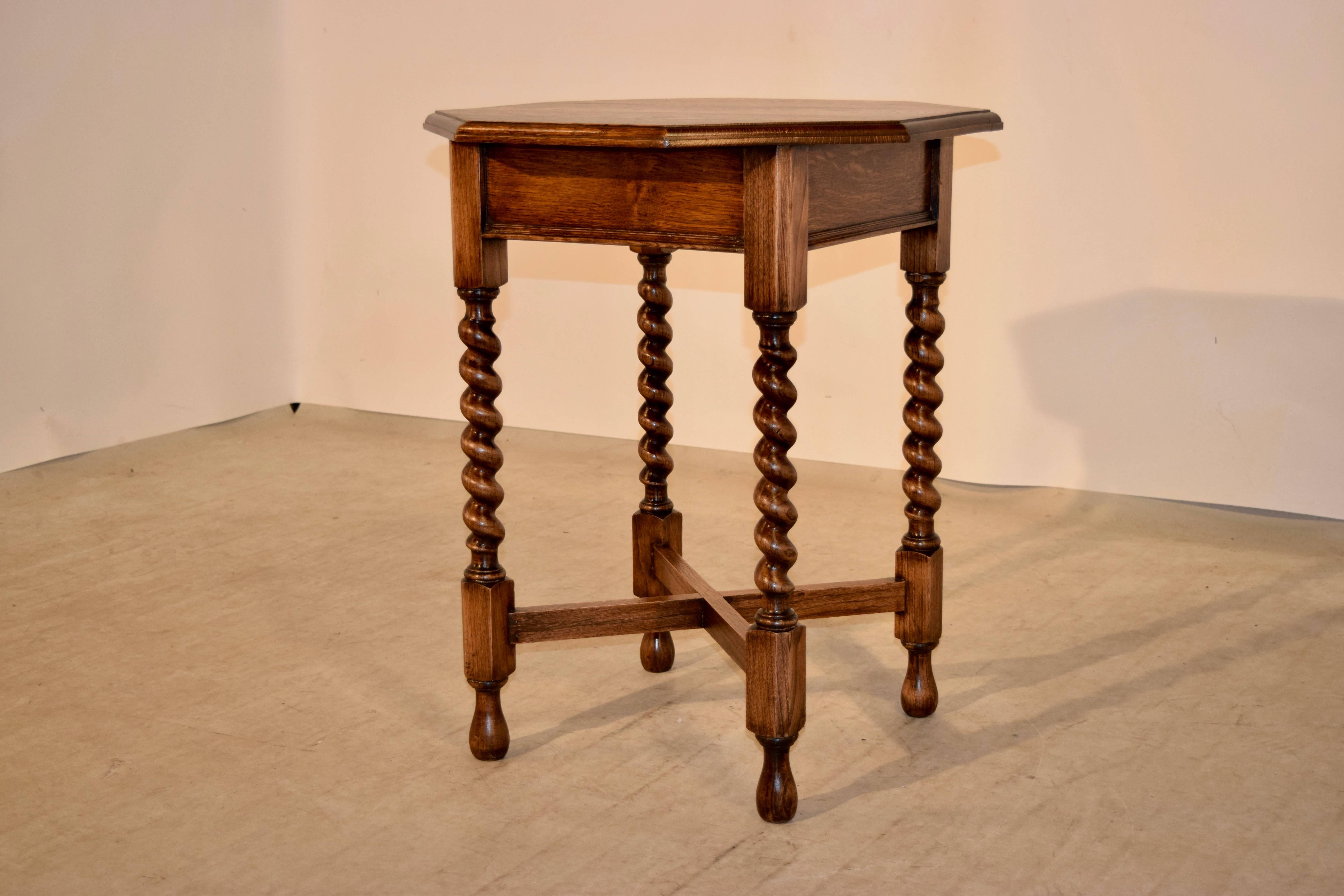 Late 19th century English oak side table with an octagonal shaped top which is bevelled around the edge, following down to a simple panelled apron and supported on thickly hand turned barley twist legs, joined by simple cross stretchers and