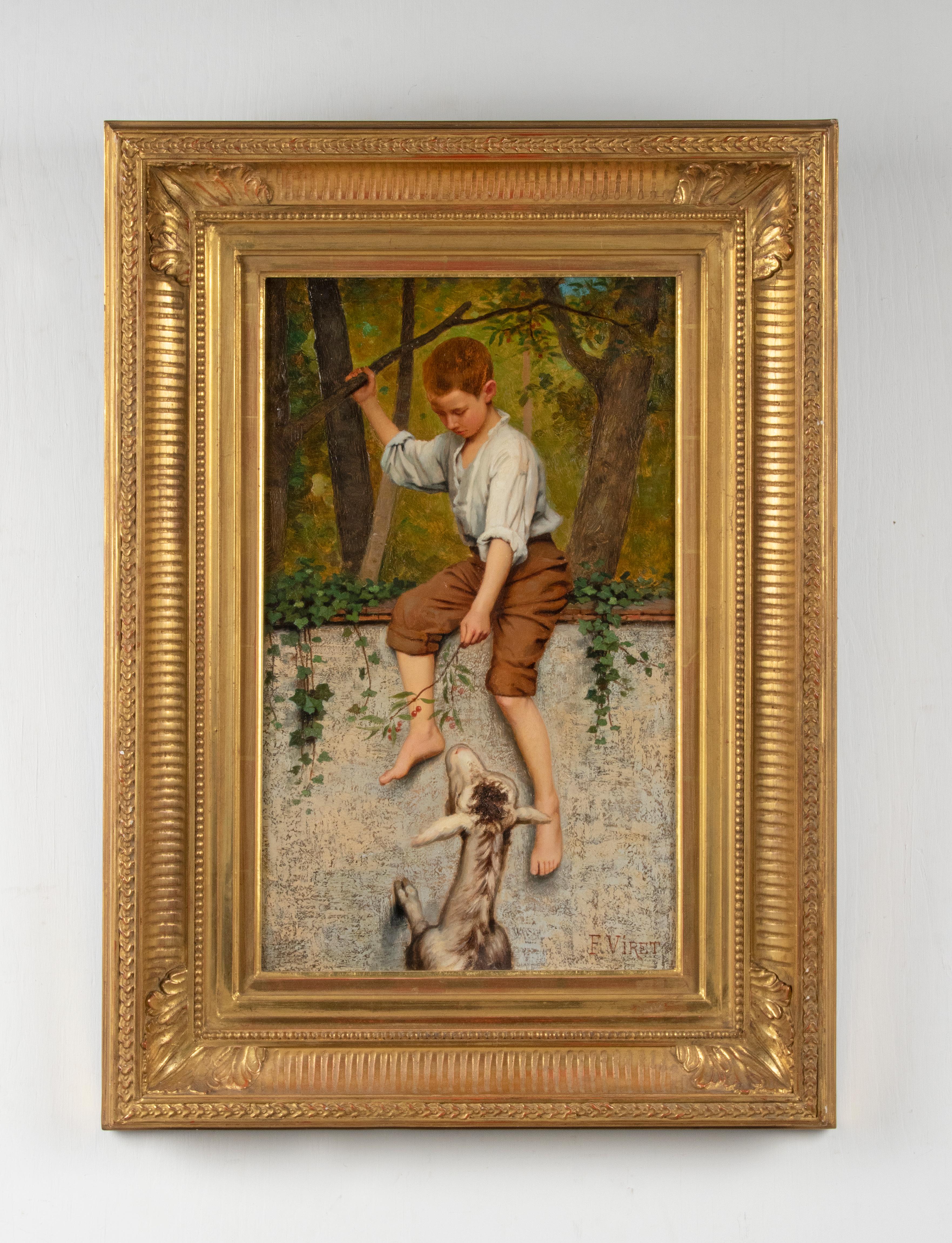 A fine oil painting depicting a boy feeding a goat with berries. it's painted on a wooden panel. Signed right under: Frédéric Viret. In an elegant gold leaf frame. The paint and the frame are in good condition. Made in France, circa