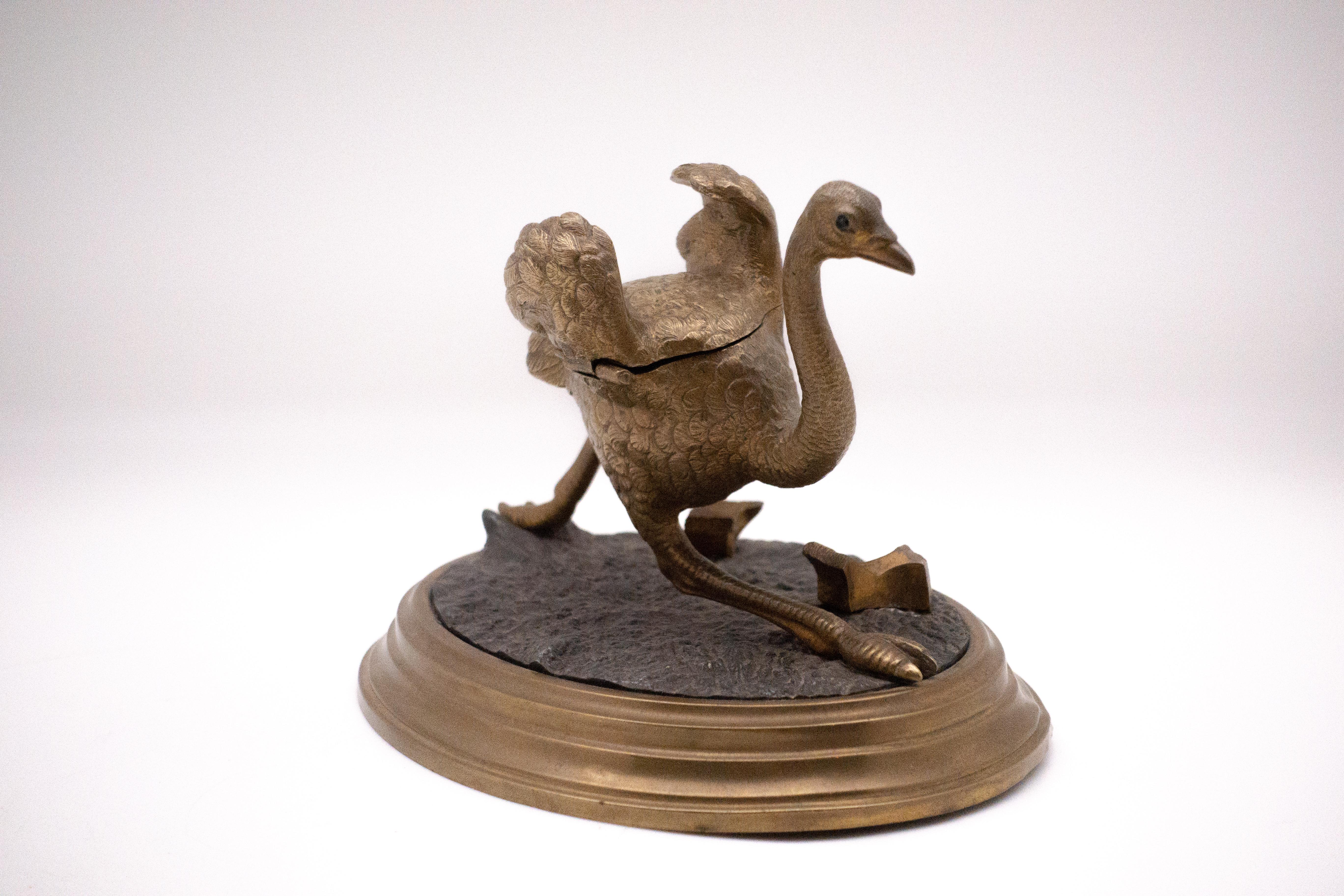 Late 19th century ostrich in motion inkwell. Two stones in bronze serve as the quill holder and top opens but the porcelain ink pot is missing.