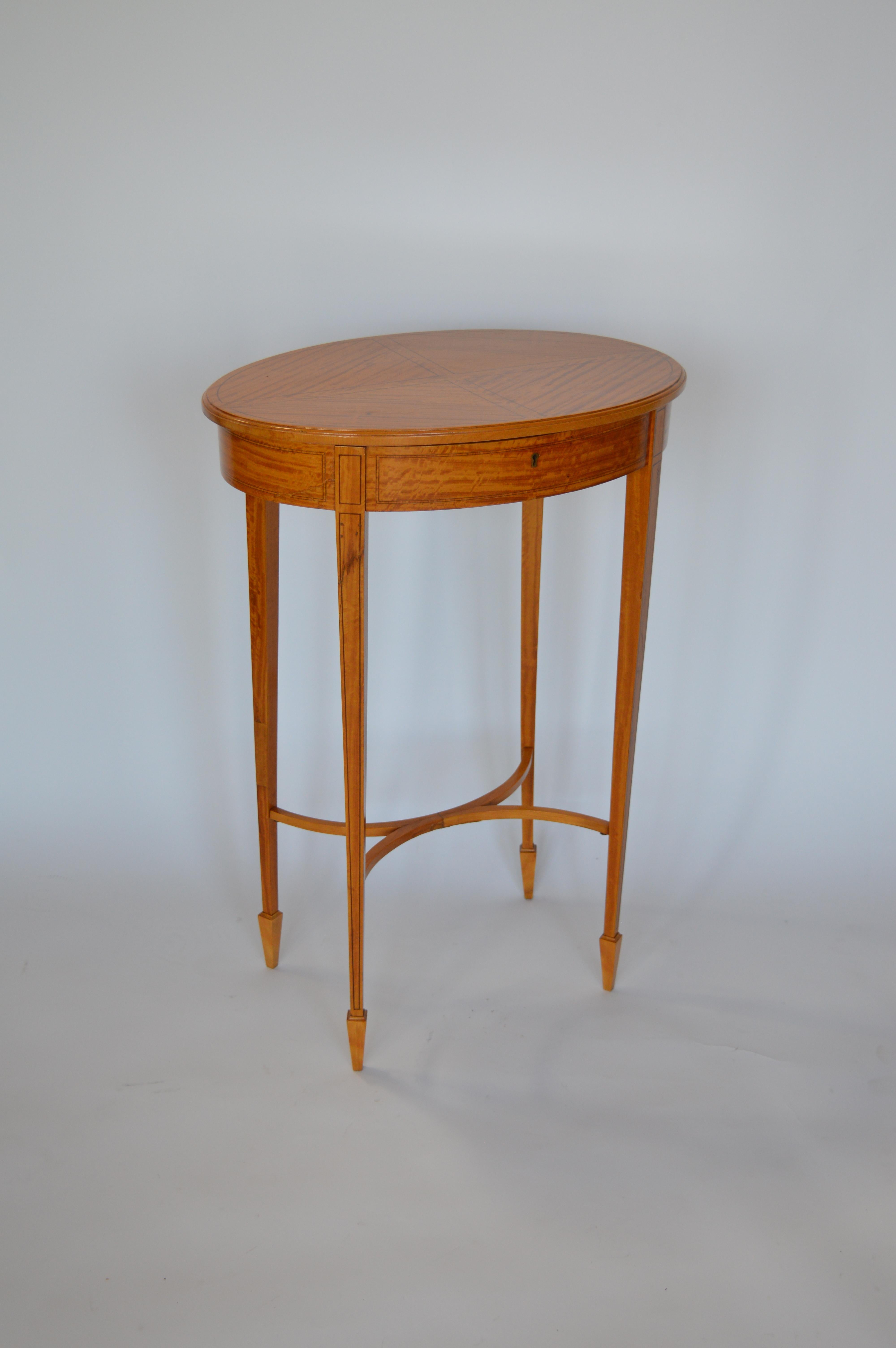 Late 19th century oval satinwood sewing table/stand. Hinged top and fitted interiors. 
 
*Does not include key.