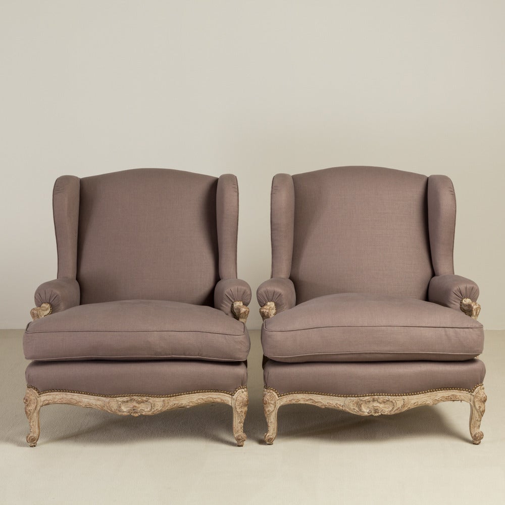 A pair of late 19th century oversized French armchairs with ornate carving to the painted frame and beading around the upholstery.
 
 