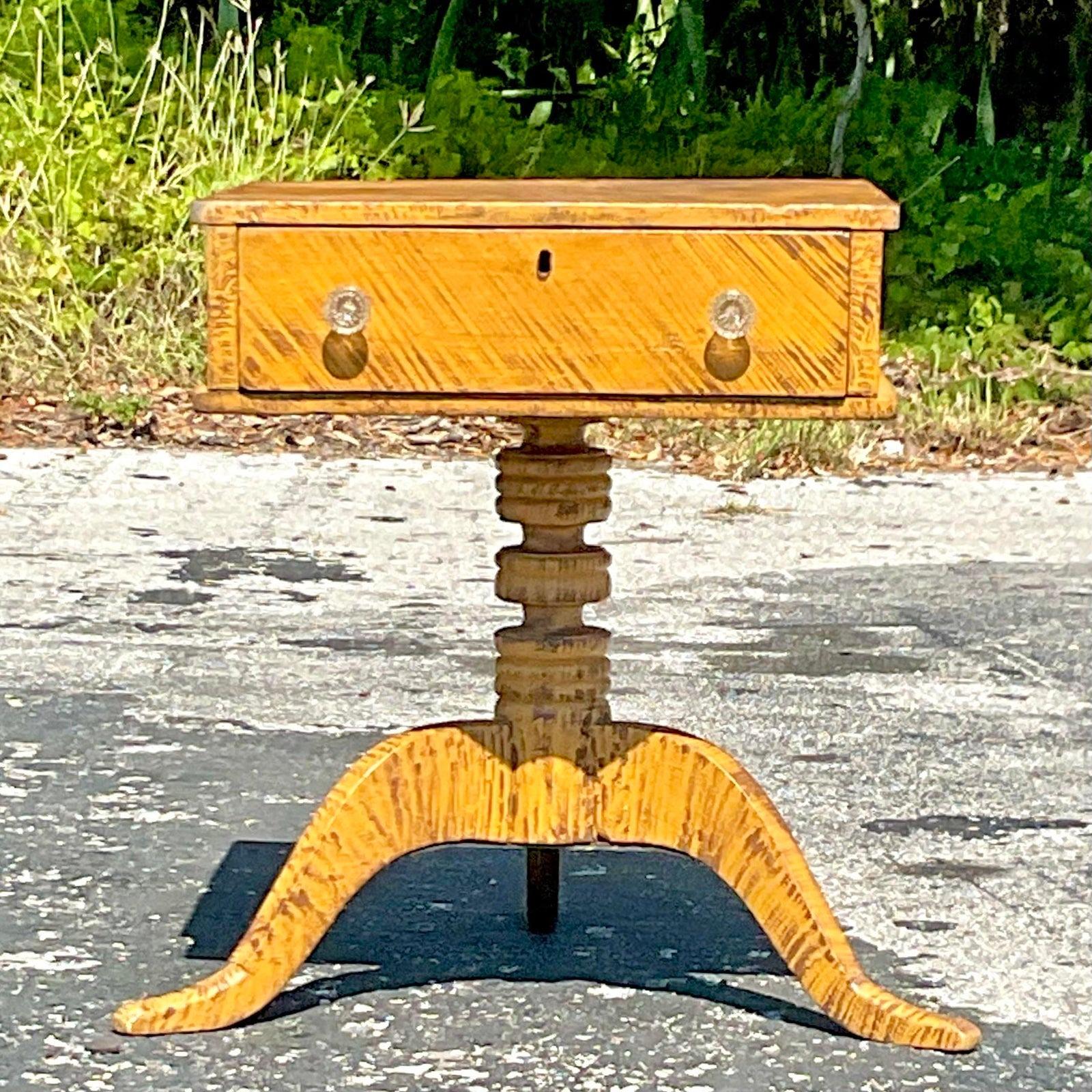 A stunning late 19th century sewing table with a single drawer and original glass knobs. The table sits on three splayed legs from a central column. Acquired at a Palm Beach estate.